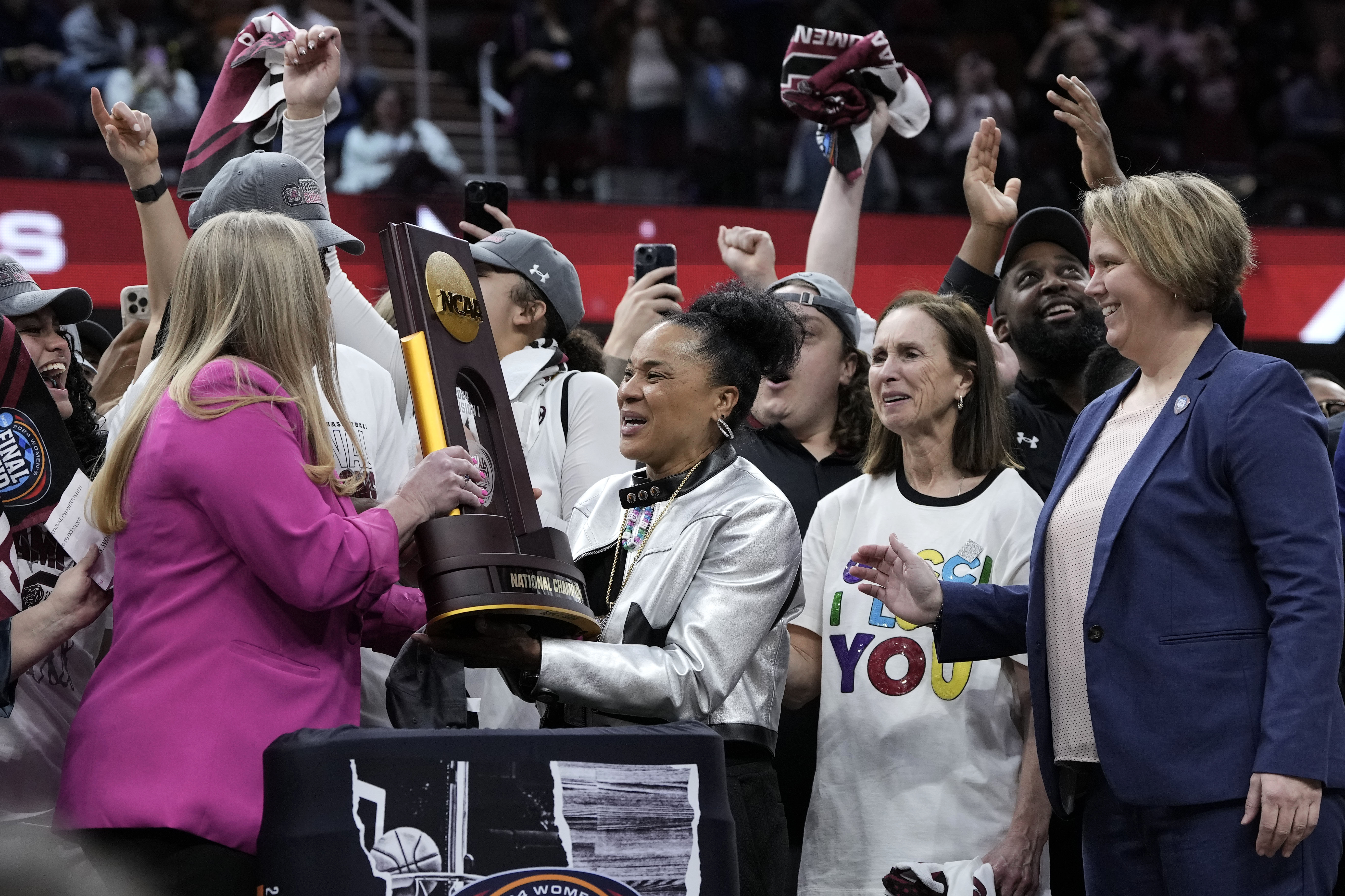 South Carolina head coach Dawn Staley, center, celebrates with the trophy after the Final Four college basketball championship game against Iowa in the women's NCAA Tournament, Sunday, April 7, 2024, in Cleveland. South Carolina won 87-75. 
