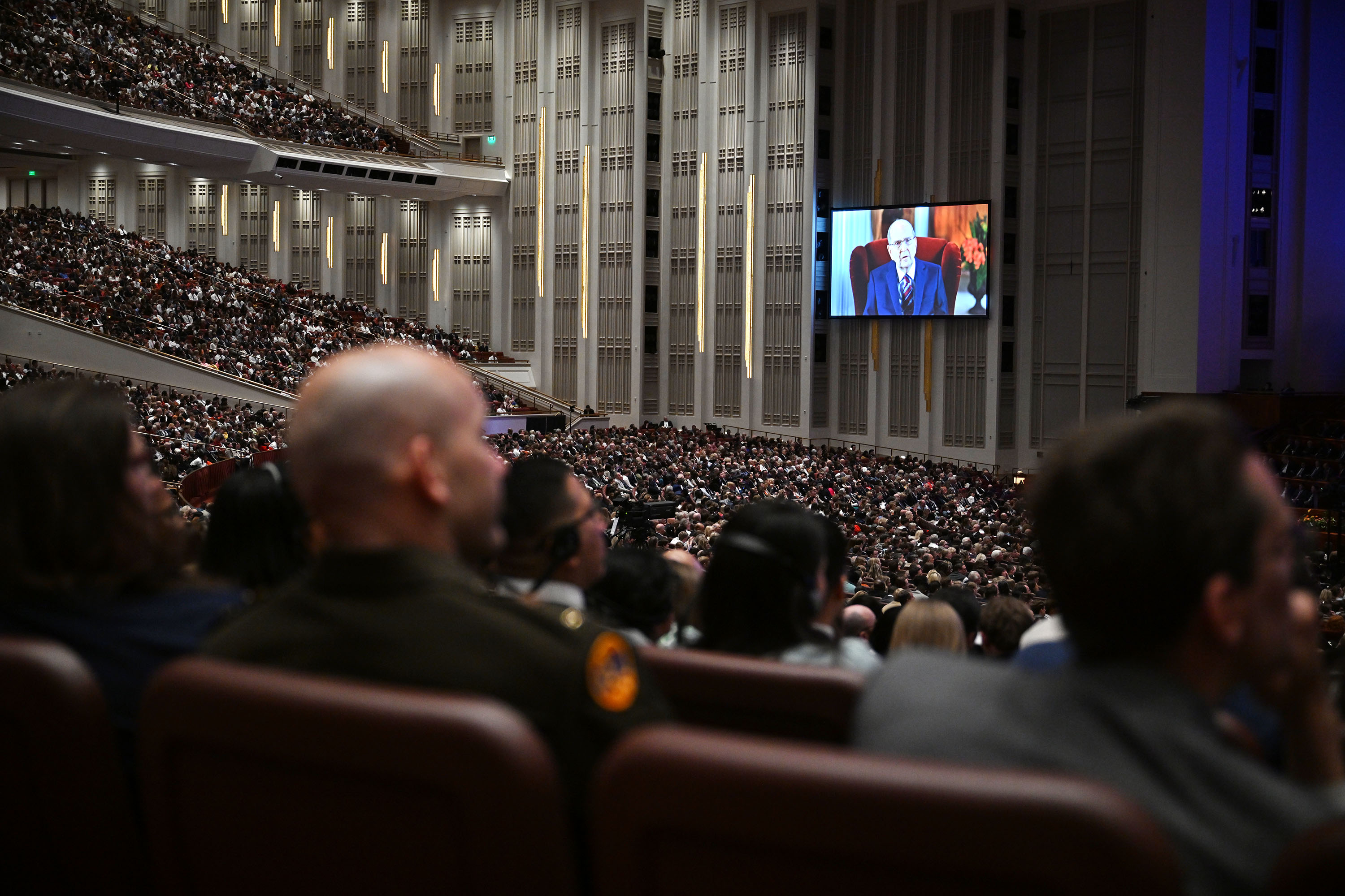 Audience members watch as President Russell M. Nelson of The Church of Jesus Christ of Latter-day Saints delivers his talk by recorded video during the afternoon session of the 194th Annual General Conference of The Church of Jesus Christ of Latter-day Saints at the Conference Center in Salt Lake City on Sunday, April 7, 2024.