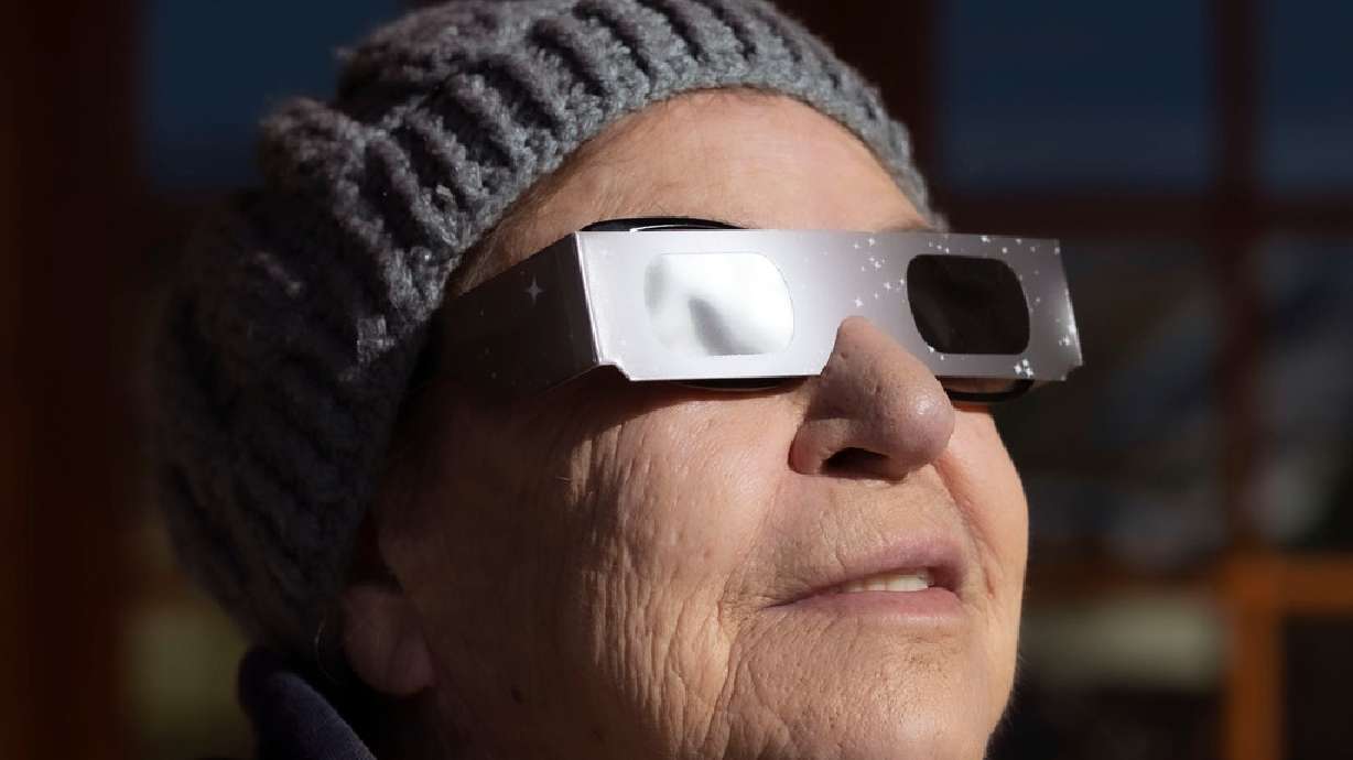 Kathy Henley watches an annular solar eclipse in Torrey, Wayne County, on Oct. 14, 2023. Excitement over Monday's eclipse is shining new light on a decades-old song.