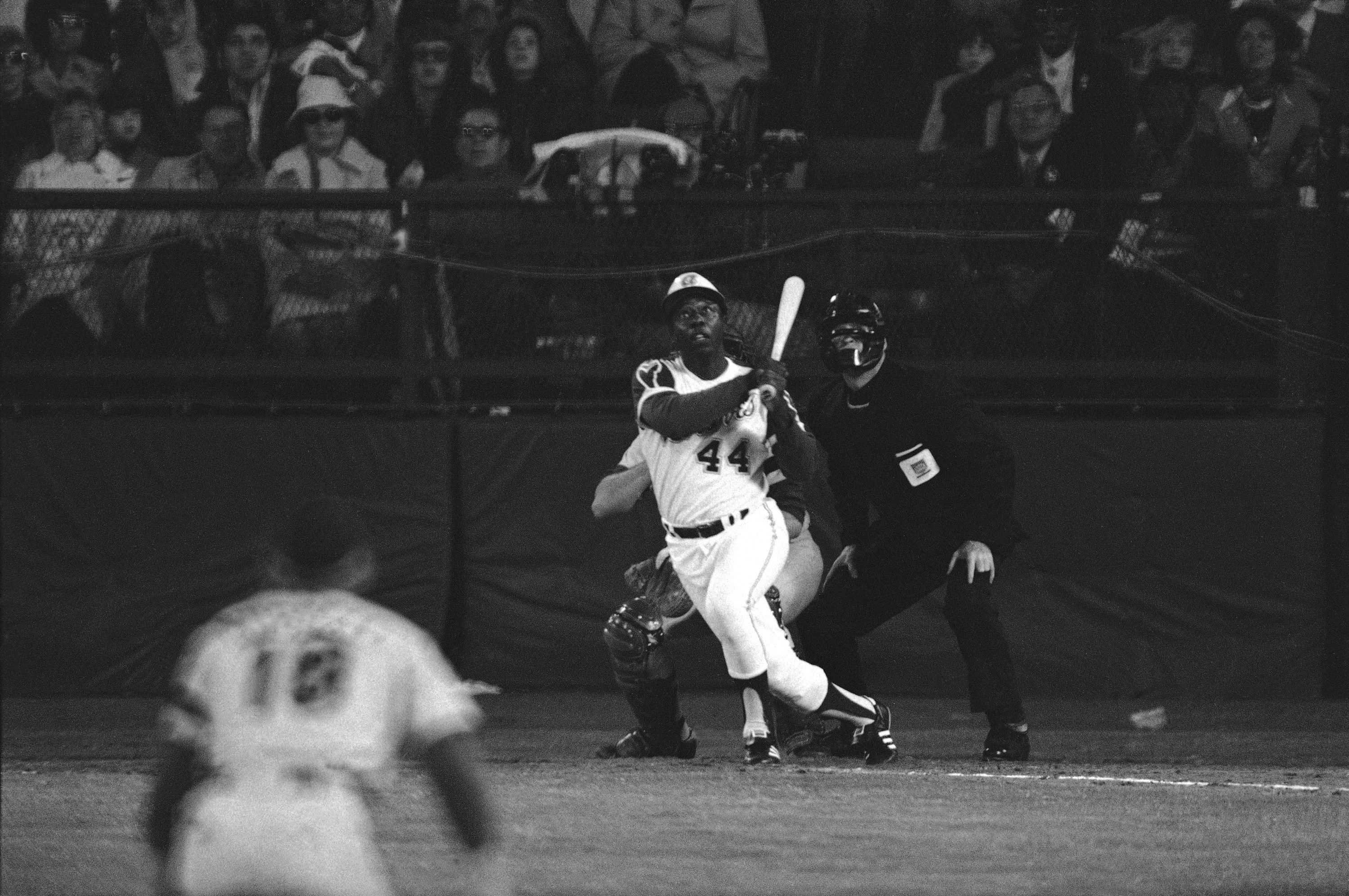 FILE - Atlanta Braves' Hank Aaron eyes the flight of the ball after hitting his 715th career homer in a game against the Los Angeles Dodgers in Atlanta, Ga., Monday night, April 8, 1974. Aaron broke Babe Ruth's record of 714 career home runs. Dodgers southpaw pitcher Al Downing, catcher Joe Ferguson and umpire David Davidson look on. Just in time for the 50-year anniversary of Hank Aaron's record 715th home run, Charlie Russo is making available video he shot of the homer. 