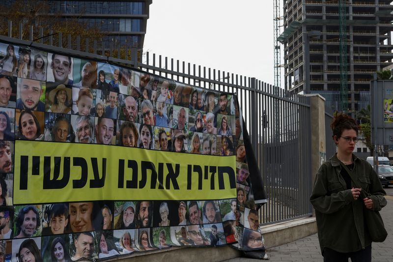 A person walks past posters with pictures of hostages kidnapped in the deadly Oct. 7 attack on Israel by the Palestinian Islamist group Hamas from Gaza, in Tel Aviv, Israel, Sunday.