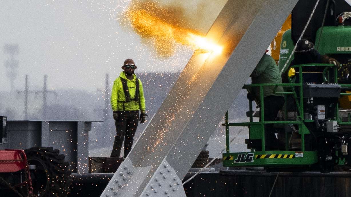 Workers are seen in the beginning stages of dismantling the steel from the frame of the collapsed Francis Scott Key Bridge, using an exothermic cutting torch, April 4, in Baltimore.