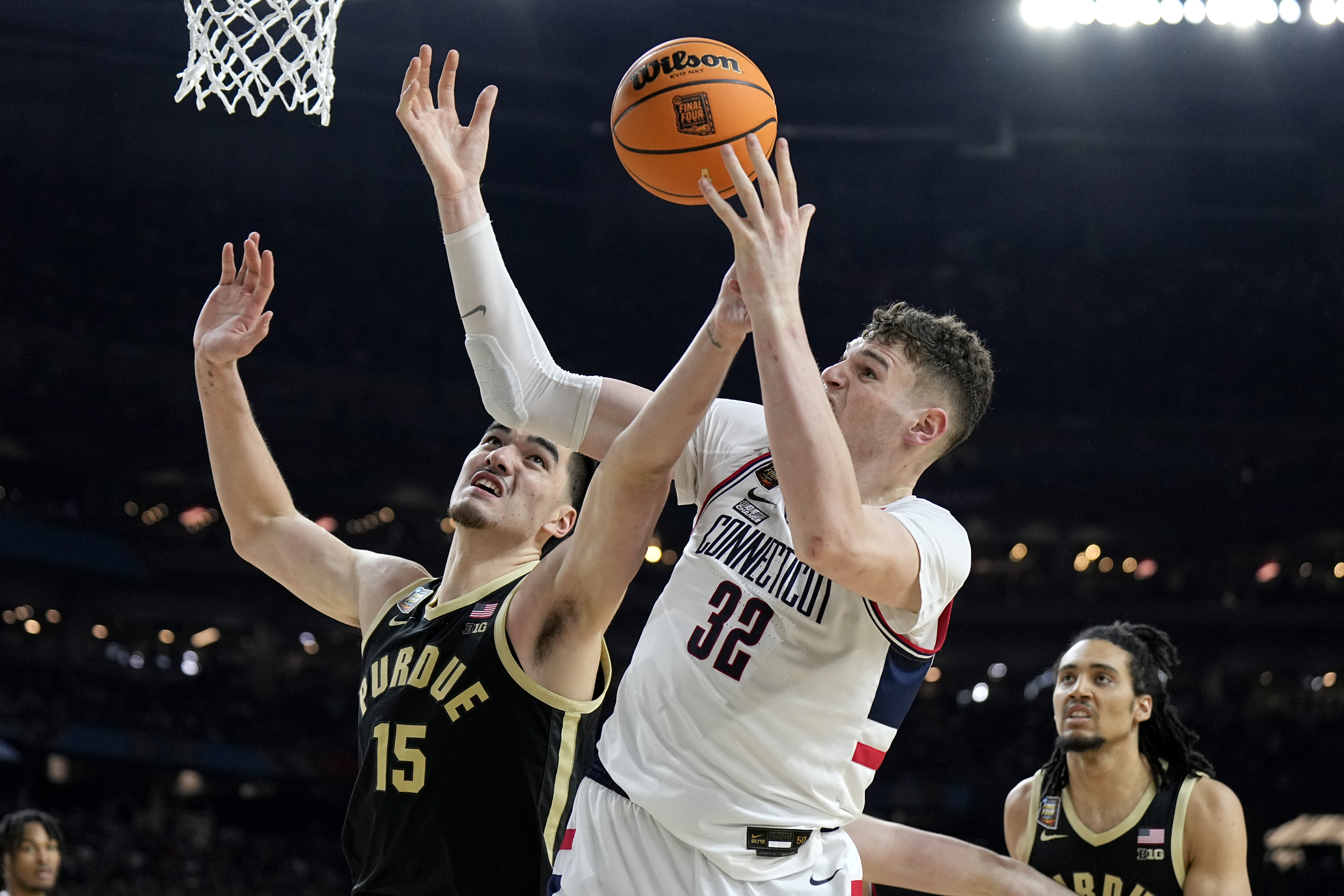 UConn center Donovan Clingan (32) and Purdue center Zach Edey battle for the rebound during the second half of the NCAA college Final Four championship basketball game, Monday, April 8, 2024, in Glendale, Ariz. 