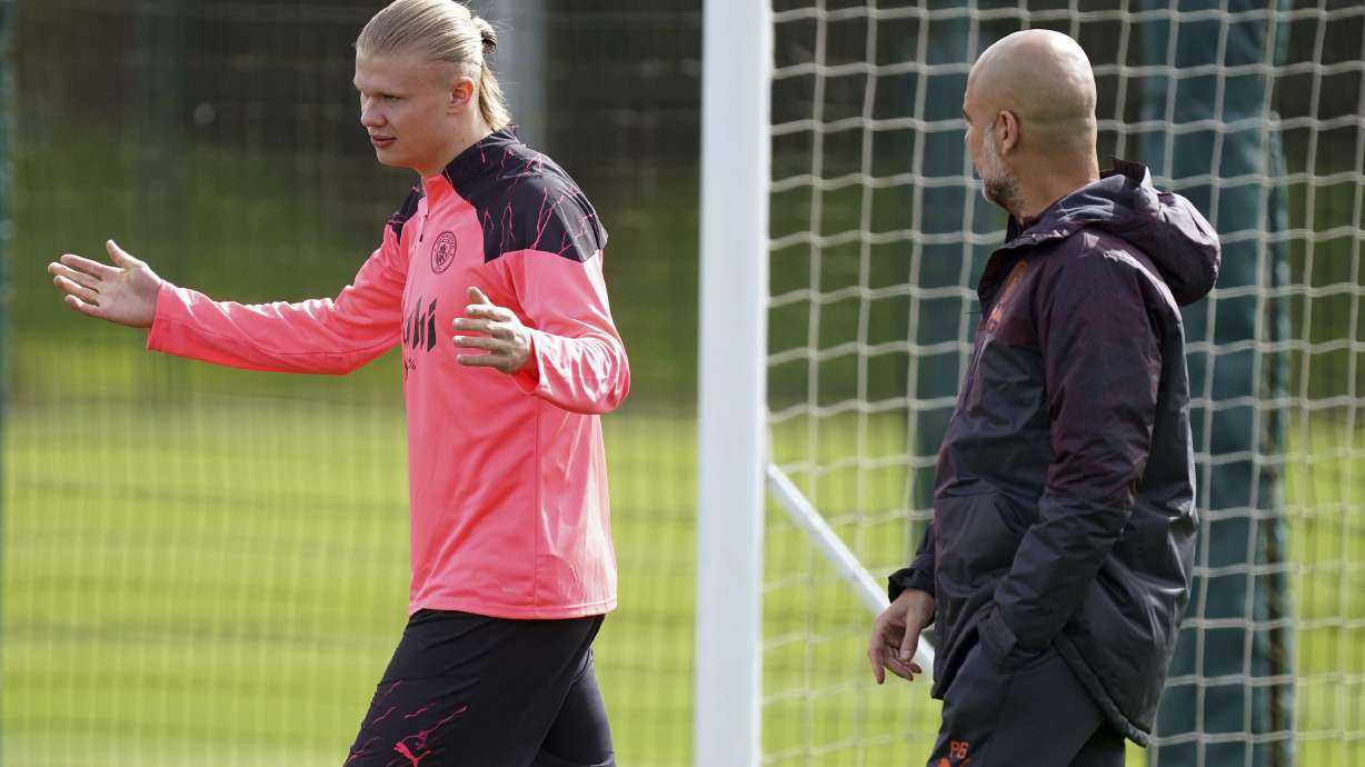 Manchester City's Erling Haaland, left, speaks with manager Pep Guardiola, during a training session at the City Football Academy, in Manchester, England, Monday April 8, 2024, ahead of a Champions League Quarter final, leg 1 soccer match against Real Madrid on Tuesday.