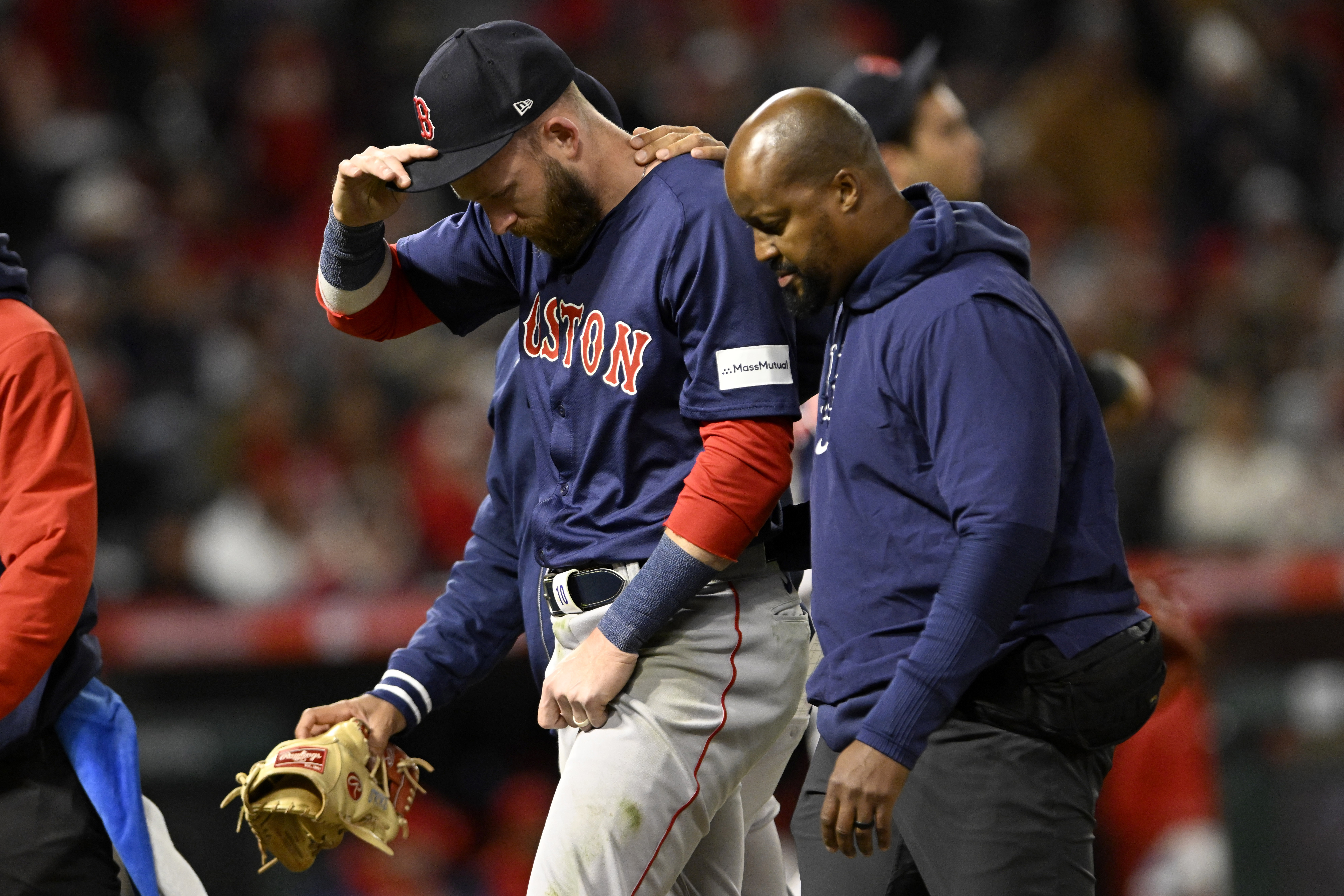 Boston Red Sox shortstop Trevor Story, left, walks off the field after being injured on a single by Los Angeles Angels' Mike Trout during the fourth inning of a baseball game in Anaheim, Calif., Friday, April 5, 2024. 