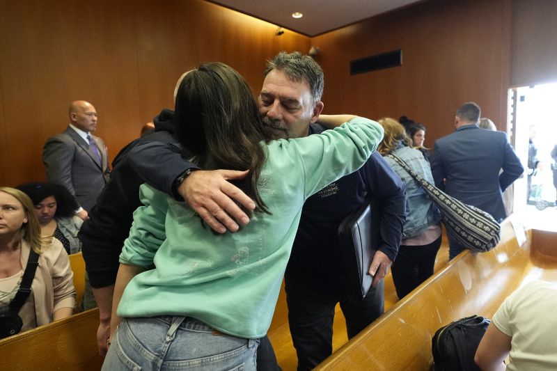 Buck Myre hugs Reina St. Juliana, Hana St. Juliana's sister, after the sentencing of James and Jennifer Crumbley, Tuesday, in Pontiac, Mich.
