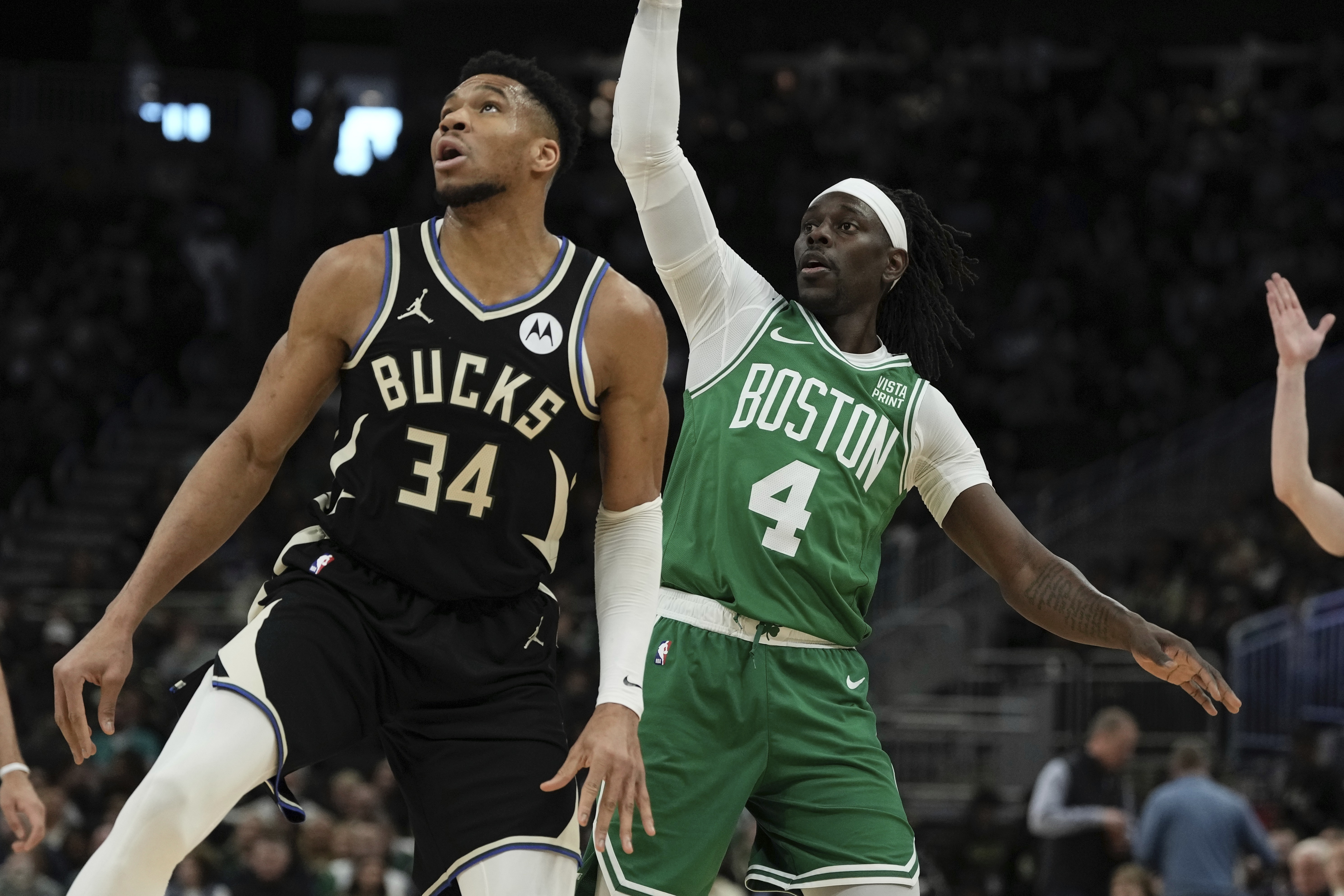Boston Celtics' Jrue Holiday watches his shot with Milwaukee Bucks' Giannis Antetokounmpo during the first half of an NBA basketball game Tuesday, April 9, 2024, in Milwaukee. 