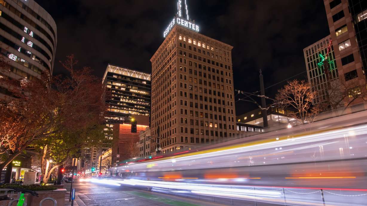 A TRAX train moves past the Walker Center, 111 Main and other downtown Salt Lake City buildings lit up in a golden hue Tuesday night. Several downtown buildings will be illuminated gold from through Saturday night, to welcome the International Olympic Committee visiting the region this week.