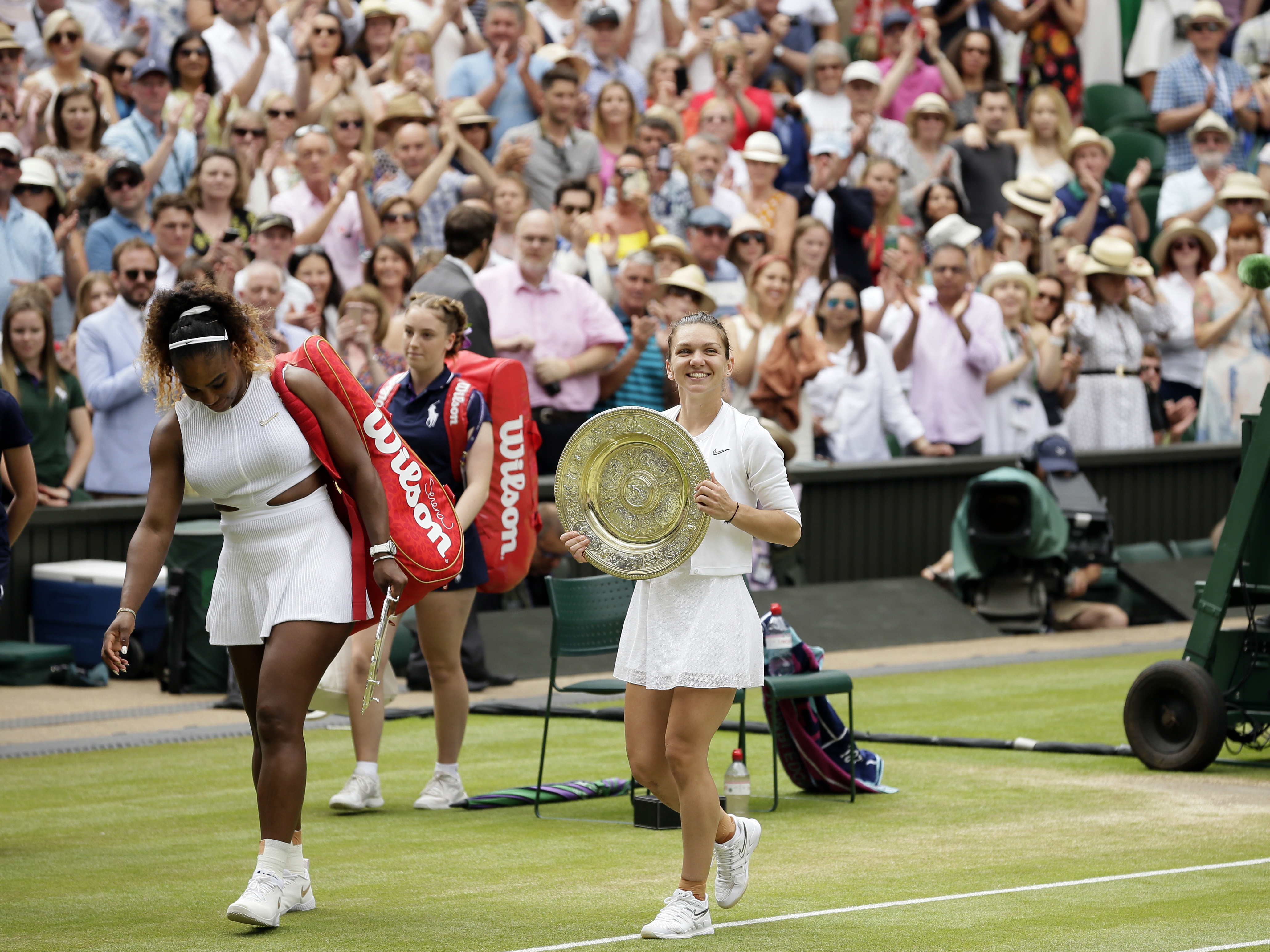 FILE - Romania's Simona Halep walks away with her trophy after defeating United States' Serena Williams, left, in the women's singles final match on day twelve of the Wimbledon Tennis Championships in London, Saturday, July 13, 2019. Halep tells The Associated Press she was nervous while flying to her first tennis tournament in 1 1/2 years. She thought her career might be finished when she was given a four-year penalty by the International Tennis Integrity Agency after testing positive for the banned drug Roxadustat at the 2022 U.S. Open, where she lost in the first round. 
