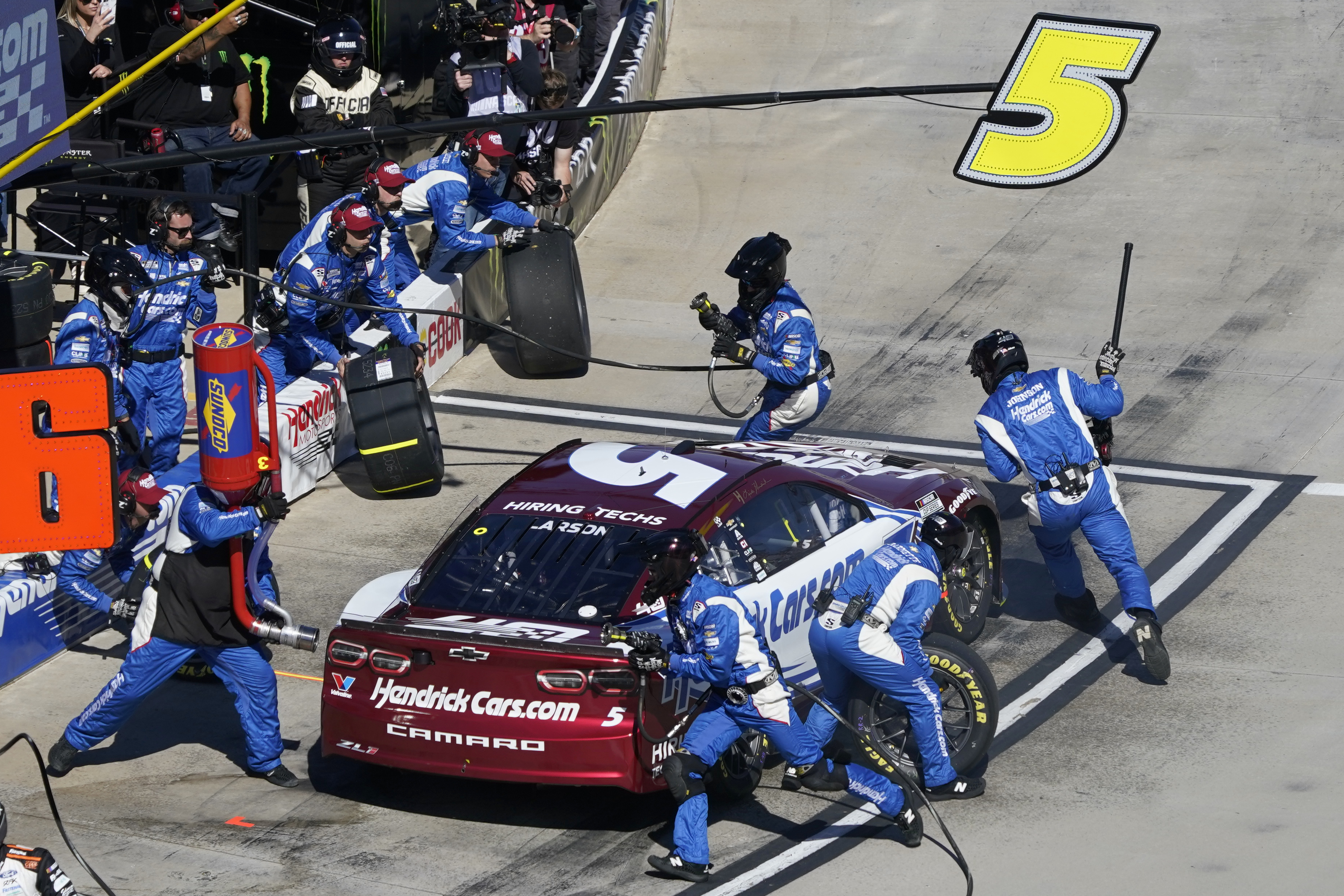 Crew members perform a pit stop on driver Kyle Larson's car during a NASCAR Cup Series auto race at Martinsville Speedway in Martinsville, Va., Sunday, April 7, 2024. 