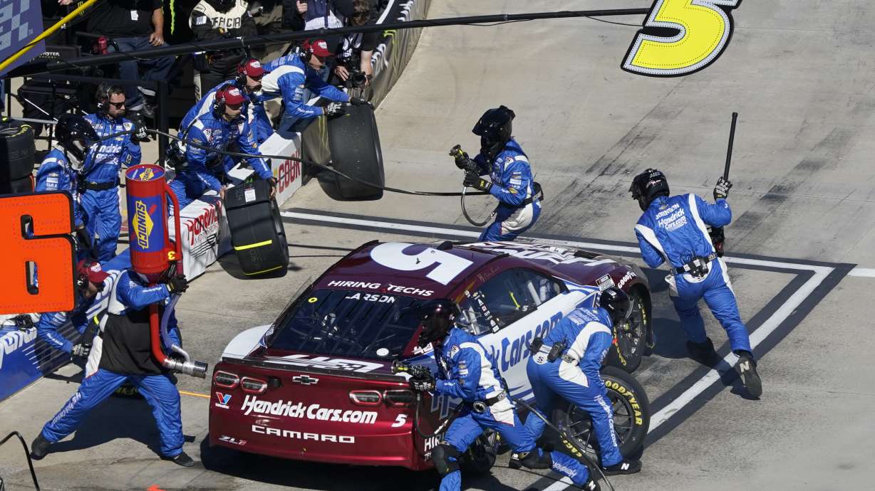 Crew members perform a pit stop on driver Kyle Larson's car during a NASCAR Cup Series auto race at Martinsville Speedway in Martinsville, Va., Sunday, April 7, 2024.
