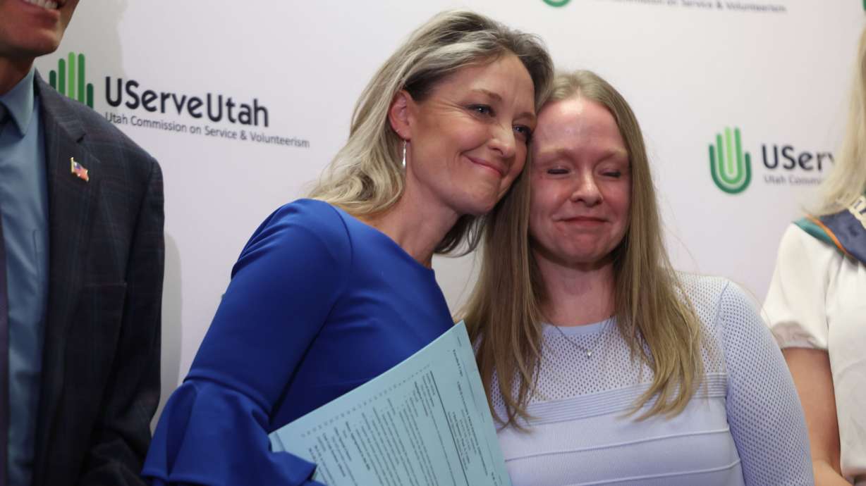 Leah Moses, mother of Om Moses Gandhi, left, and Shaynie Hunter embrace after the signing of HB272 at the University of Utah Bennion Center in Salt Lake City on Wednesday.