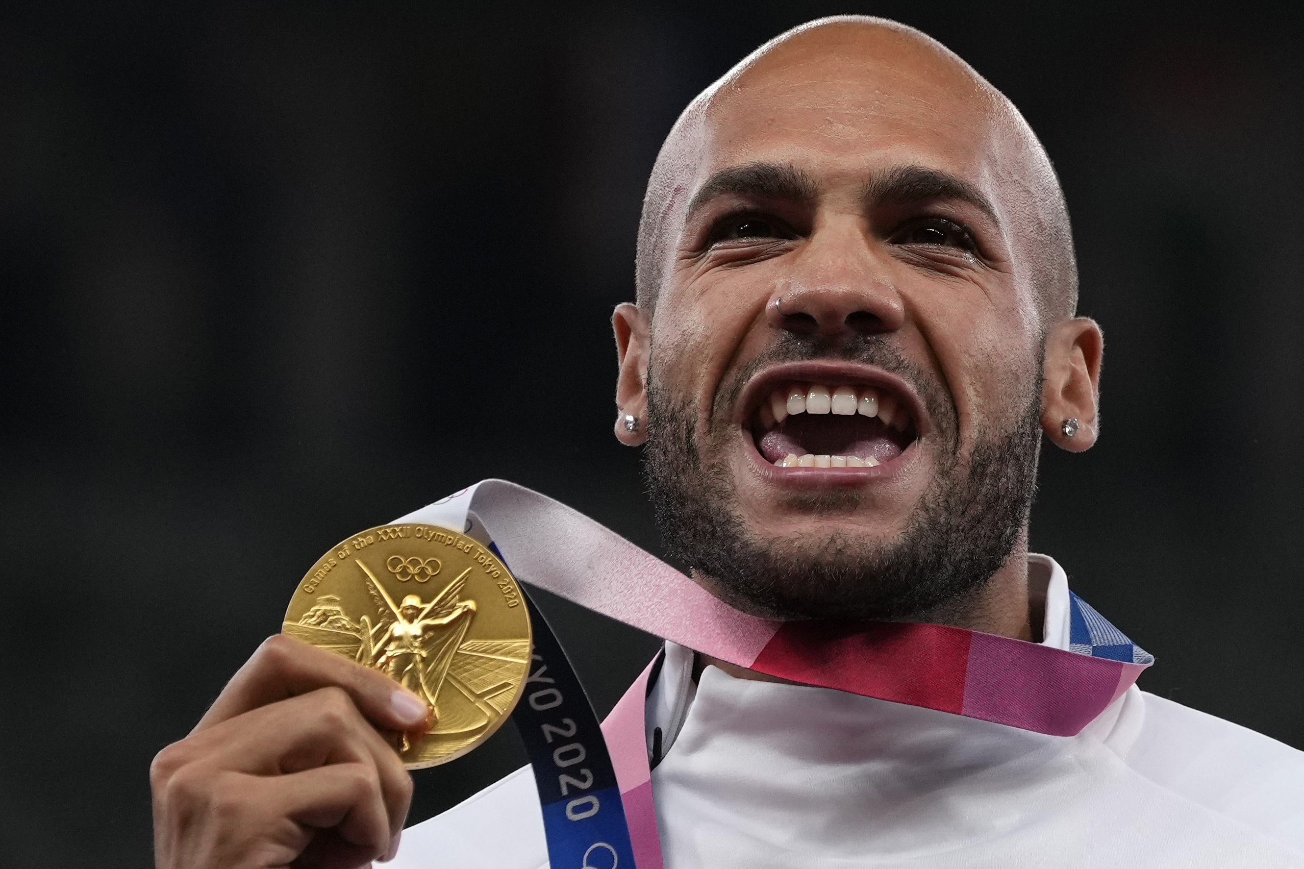 FILE - Lamont Marcell Jacobs, of Italy poses with his gold medal following the men's 100-meters final at the 2020 Summer Olympics, Monday, Aug. 2, 2021, in Tokyo. Track and field is set to become the first sport to introduce prize money at the Olympics, with World Athletics saying Wednesday, April 10, 2024, it would pay $50,000 to gold medalists in Paris. 