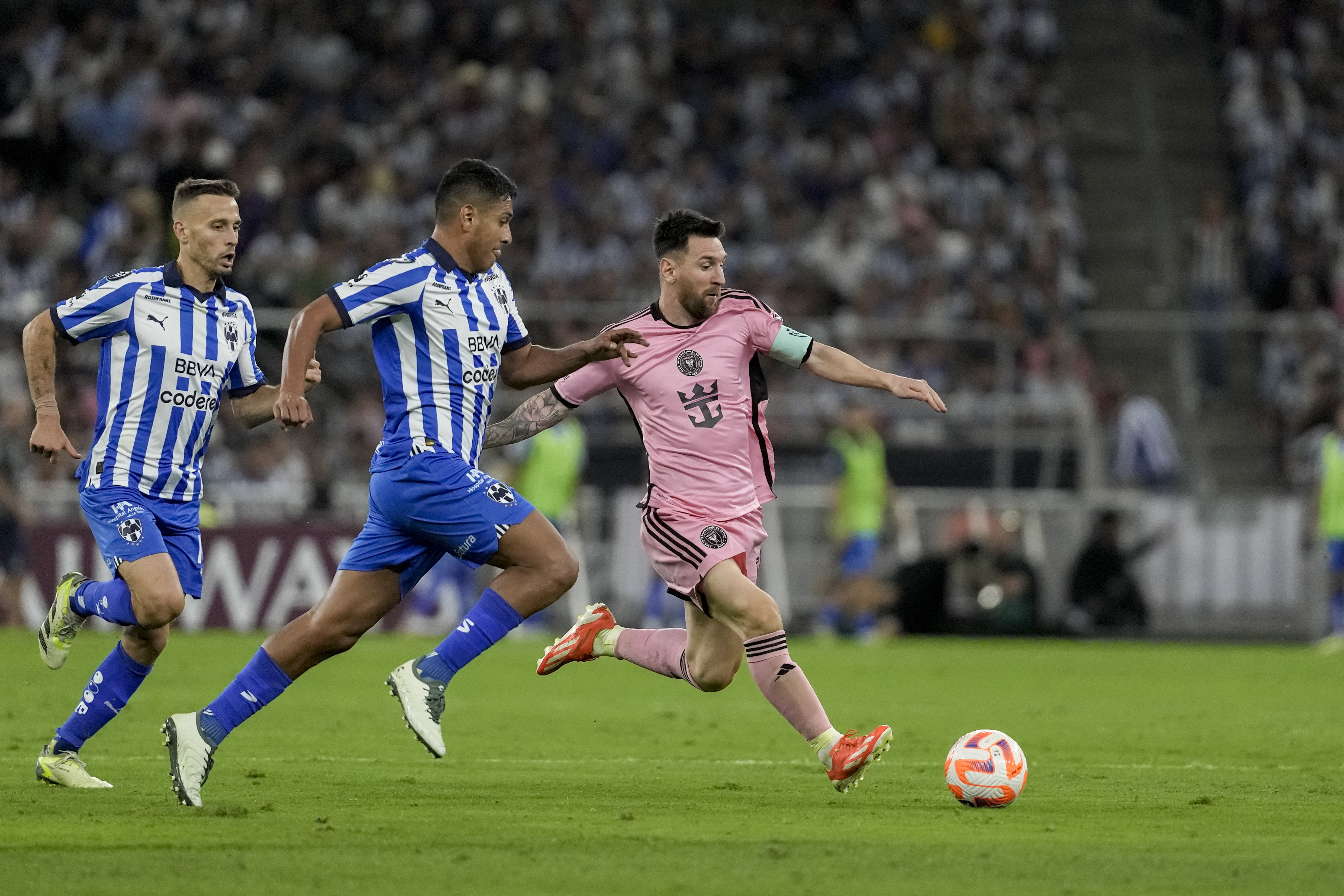 Inter Miami's Lionel Messi, right, tries control the ball past Monterrey's Luis Romo during a CONCACAF Champions Cup quarter final second leg soccer match at the BBVA stadium in Monterrey, Mexico, Wednesday, April 10, 2024. 
