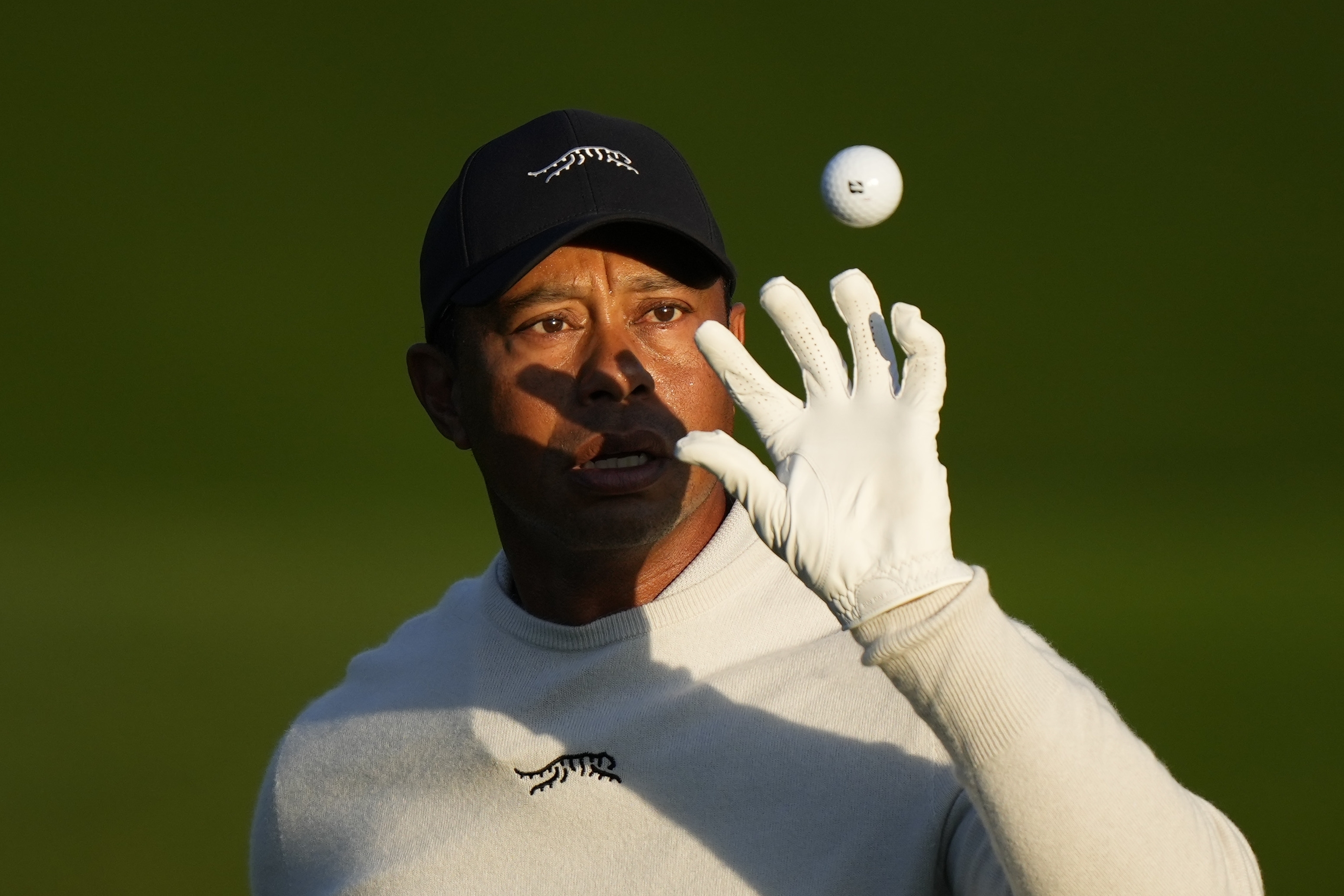 Tiger Woods catches a golf ball on the driving range during a practice round in preparation for the Masters golf tournament at Augusta National Golf Club Monday, April 8, 2024, in Augusta, Ga.