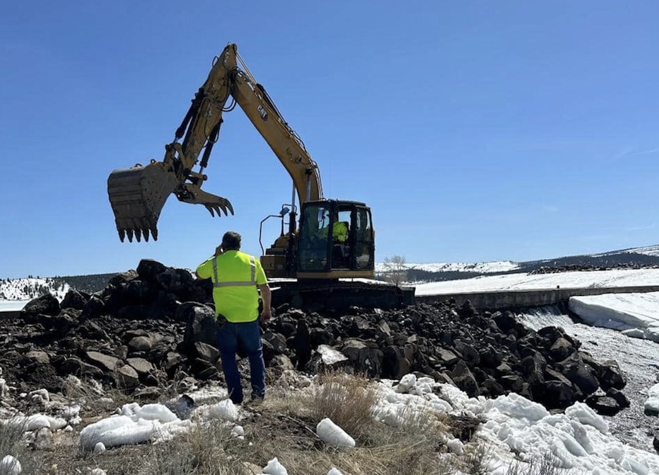 Crews build a buttress by the damaged portion of the Panguitch Lake dam on Wednesday. Utah engineers said they are encouraged by the progress made to repair the dam after damage was discovered on Monday.