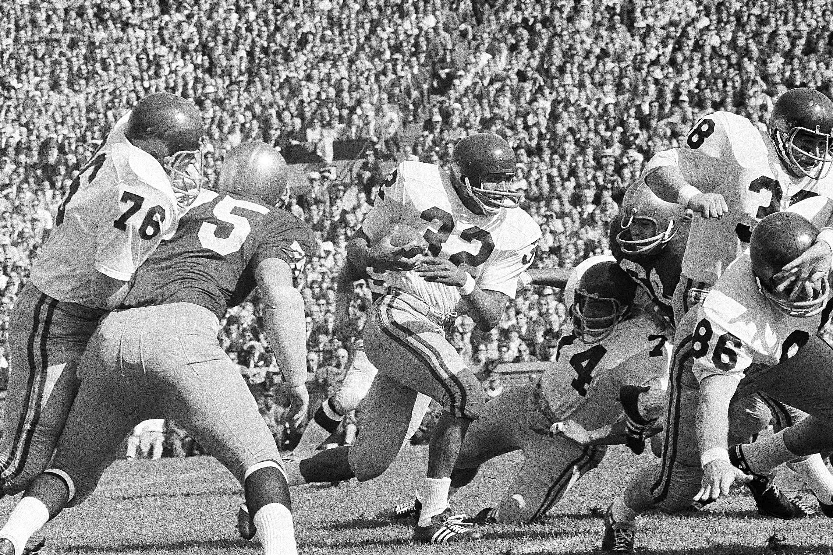FILE - University of Southern California runningback O.J. Simpson (32)runs against Notre Dame Notre Dame in the first half of an NCAA college football game in South Bend, ind., Oct. 14, 1967. and picks up a few yards in their intersectional football game, Oct. 14, 1967 in South Bend, Indiana. Blocking for USC are Bob Miller (86), Mike Taylor (74), and Dan Scott (38). O.J. Simpson, the decorated football superstar and Hollywood actor who was acquitted of charges he killed his former wife and her friend but was found liable in a separate civil trial, has died. He was 76. The family announced on Simpson's official X account that he died Wednesday, April 10, 2024, of prostate cancer.