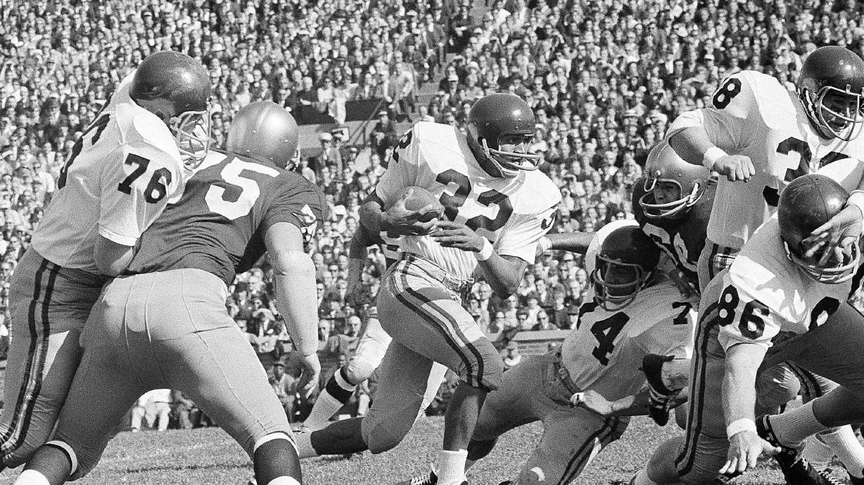 FILE - University of Southern California runningback O.J. Simpson (32)runs against Notre Dame Notre Dame in the first half of an NCAA college football game in South Bend, ind., Oct. 14, 1967. and picks up a few yards in their intersectional football game, Oct. 14, 1967 in South Bend, Indiana. Blocking for USC are Bob Miller (86), Mike Taylor (74), and Dan Scott (38). O.J. Simpson, the decorated football superstar and Hollywood actor who was acquitted of charges he killed his former wife and her friend but was found liable in a separate civil trial, has died. He was 76. The family announced on Simpson's official X account that he died Wednesday, April 10, 2024, of prostate cancer.