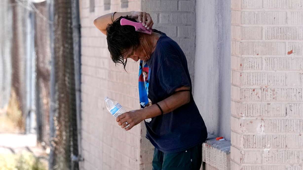 A person tries to cool off in the shade July 18, 2023, in Phoenix. Extreme temperature fluctuations linked to climate change could be a factor in roughly a half-million deaths and additional cases of disability from stroke around the world.