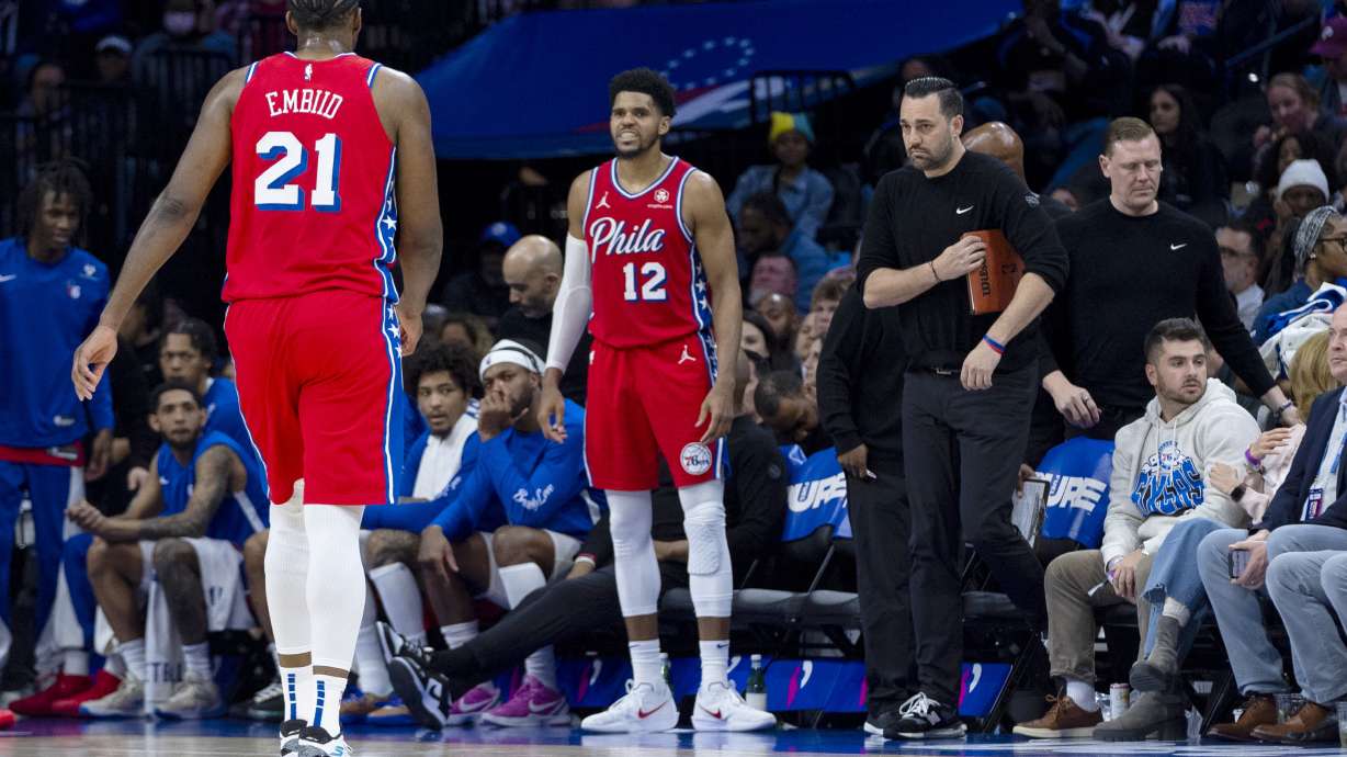 Philadelphia 76ers' Joel Embiid, left, heads off the court and straight to the locker room after grabbing his left knee on the previous possession during the first half of an NBA basketball game against the Orlando Magic, Friday, April 12, 2024, in Philadelphia.