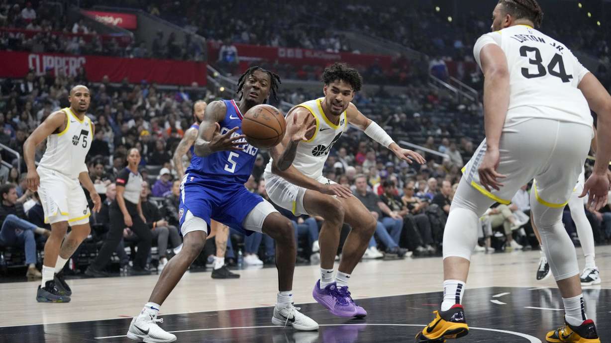 Los Angeles Clippers guard Bones Hyland (5) and Utah Jazz guard Johnny Juzang reach for the ball as Jazz guard Talen Horton-Tucker (5) and forward Kenneth Lofton Jr. (34) watch during the first half of an NBA basketball game in Los Angeles, Friday, April 12, 2024.