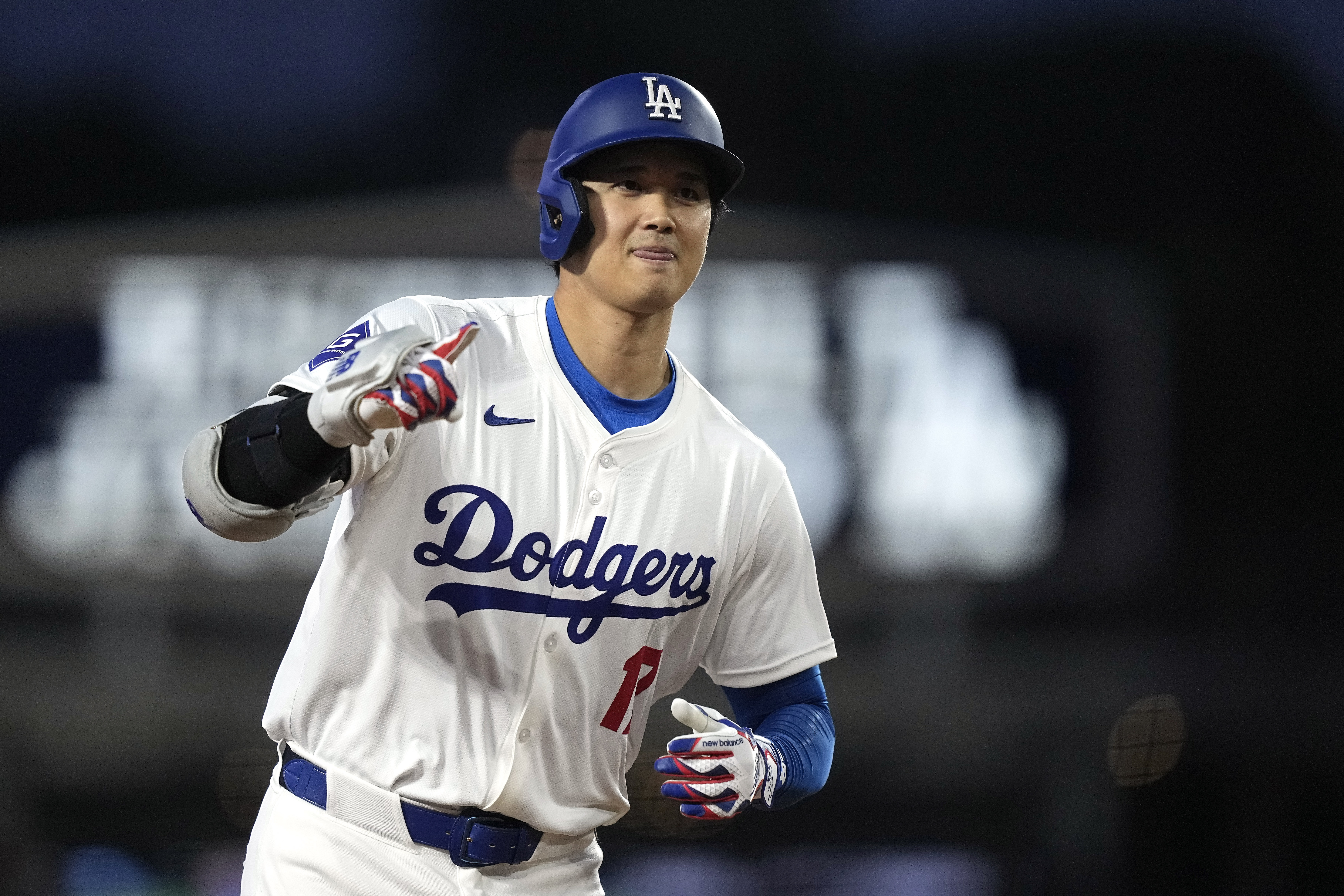Los Angeles Dodgers' Shohei Ohtani gestures as he round third after hitting a solo home run during the first inning of a baseball game against the San Diego Padres Friday, April 12, 2024, in Los Angeles. 