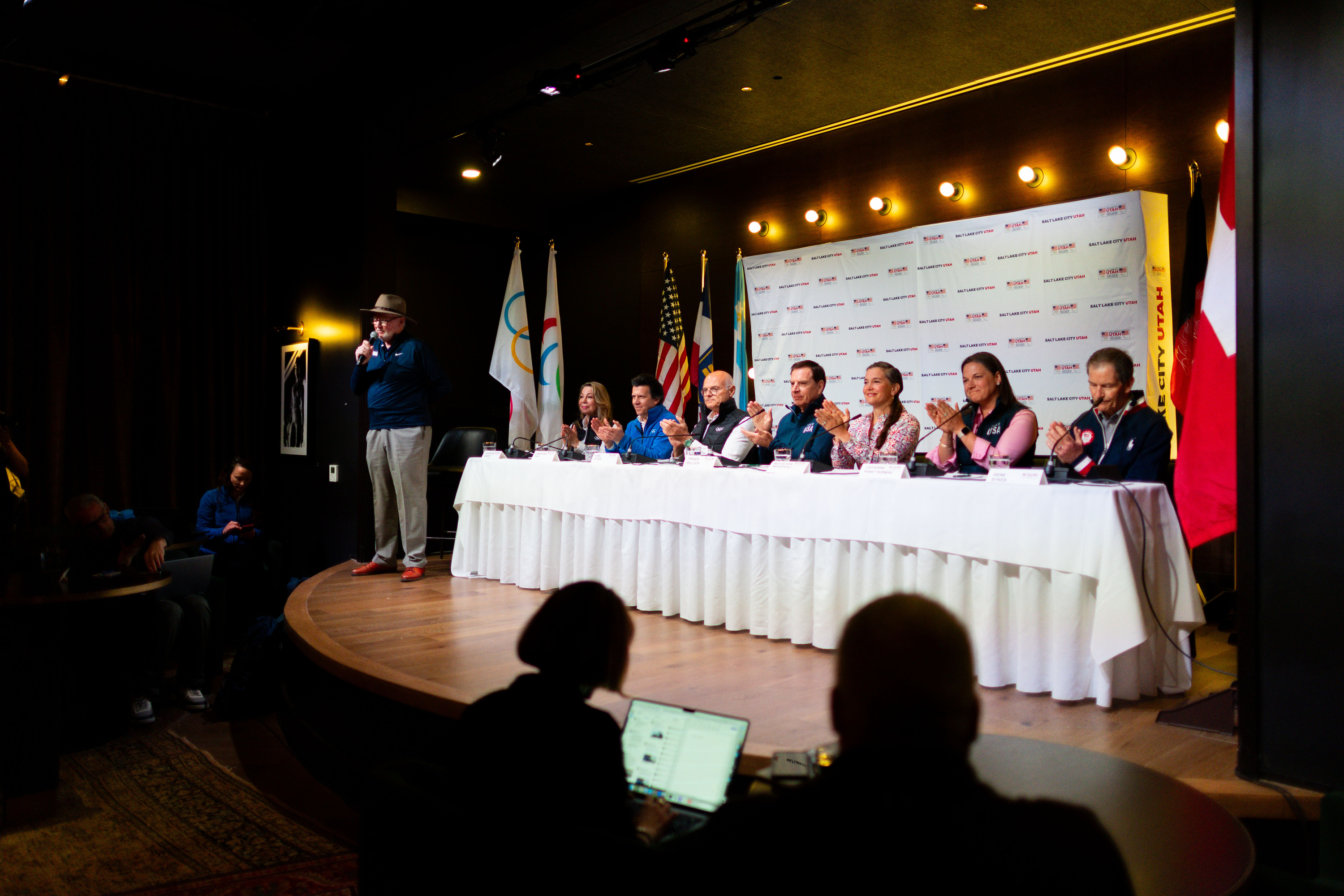 Members of the International Olympic Committee’s Future Host Commission, IOC and U.S. Olympic & Paralympic leaders applaud during a press conference Saturday during their visit to Salt Lake City to tour proposed venues for the 2034 Games at Edison House.