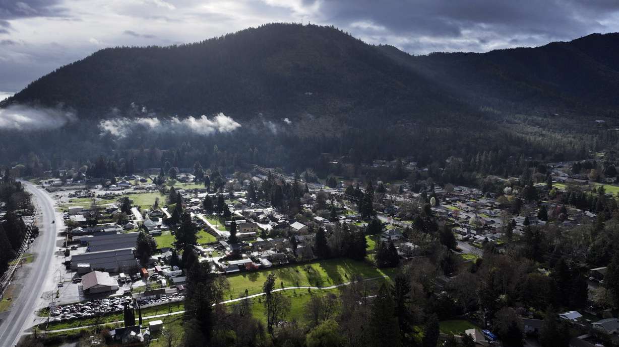 A vehicle at left drives down Rogue River Highway as light shines on the area March 23 in Grants Pass, Ore.