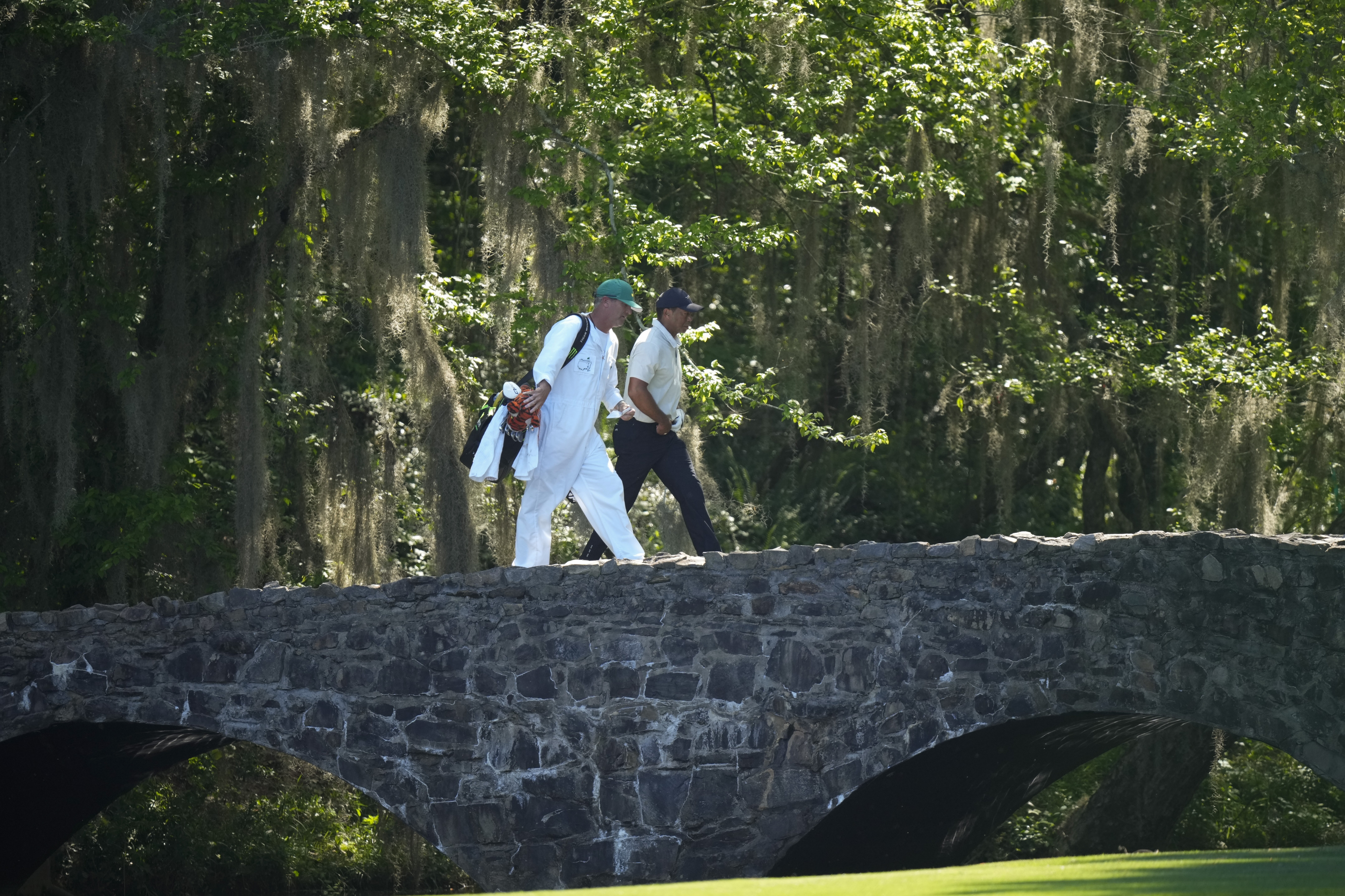 Tiger Woods walks over the Byron Nelson Bridge on the 13th hole during third round at the Masters golf tournament at Augusta National Golf Club Saturday, April 13, 2024, in Augusta, Ga.