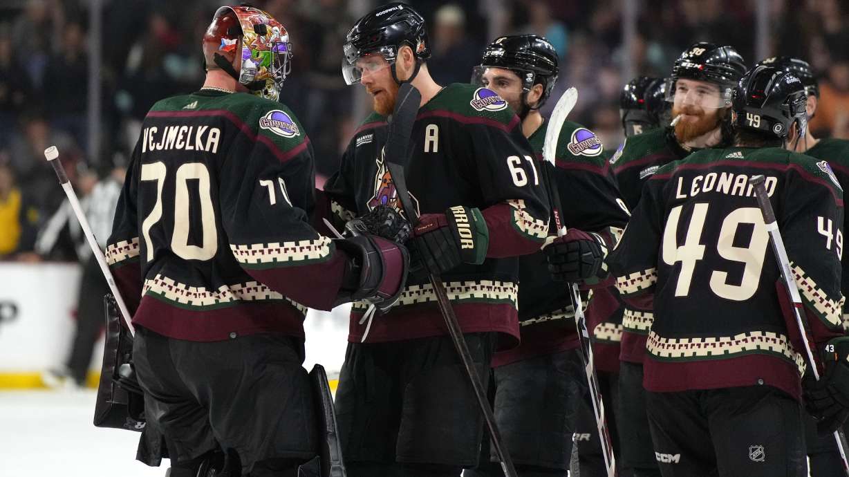 Arizona Coyotes goaltender Karel Vejmelka (70) celebrates with teammates after their win over the Seattle Kraken in an NHL hockey game, Friday, March 22, 2024, in Tempe, Ariz.