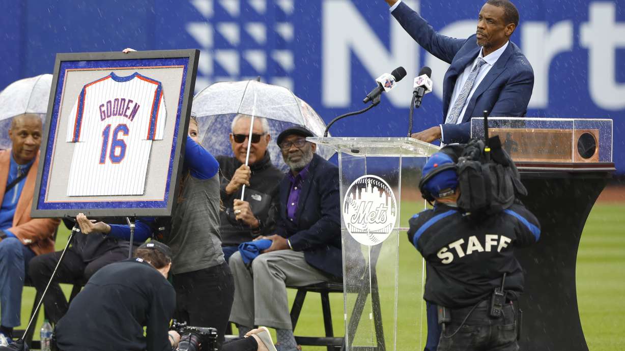 Former New York Mets pitcher Dwight Gooden, top right, acknowledges fans during a ceremony to retire his number at Citi Field before a baseball game between the Mets and the Kansas City Royals, Sunday, April 14, 2024, in New York.