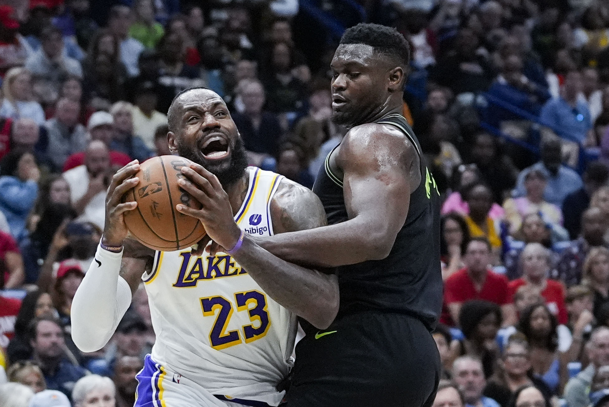 Los Angeles Lakers forward LeBron James (23) drives to the basket against New Orleans Pelicans forward Zion Williamson in the first half of an NBA basketball game in New Orleans, Sunday, April 14, 2024.