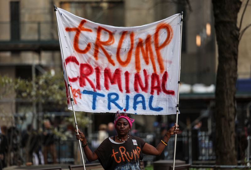 Nadine Seiler, 58, holds a banner against Republican presidential candidate and former President Donald Trump, outside the courthouse, on the day of his hush money criminal trial, in New York City, Monday.
