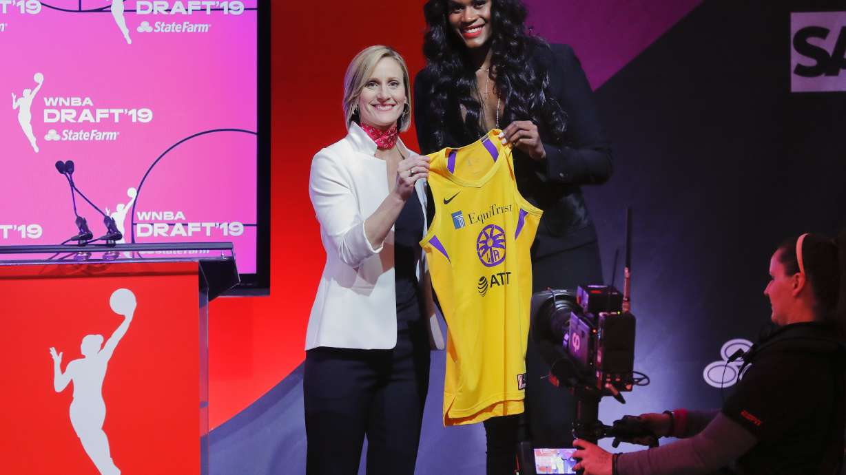 FILE - Baylor's Kalani Brown, right, poses for a photo with WNBA COO Christy Hedgpeth after being selected by the Los Angeles Sparks as the seventh overall pick in the WNBA basketball draft, April 10, 2019, in New York. Everyone likes to look good for a big night on the town. Lots of people will be watching as the WNBA’s next players turn out dressed in their finest looks for Monday night's April 15, 2024, draft.