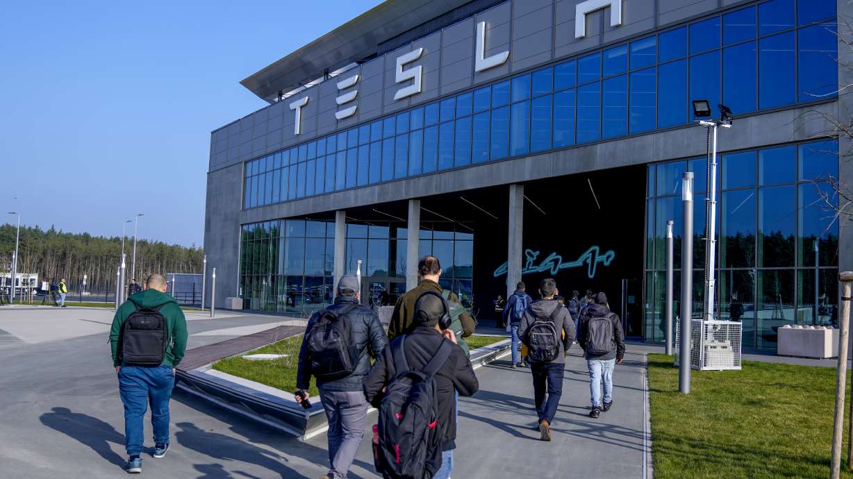 People walk to the Tesla Gigafactory for electric cars in Gruenheide near Berlin, Germany, March 13. After reporting dismal first-quarter sales, Tesla is planning to lay off about a tenth of its workforce as it tries to cut costs, multiple media outlets reported Monday.