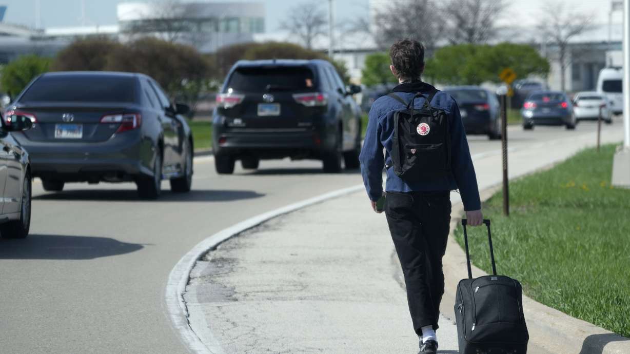A passenger walks on the highway as he carries his luggage to at O'Hare International Airport in Chicago, Monday. Pro-Palestinian demonstrators blocked a freeway leading to three Chicago O'Hare International Airport terminals Monday morning, temporarily stopping vehicle traffic into one of the nation's busiest airports and causing headaches for travelers.