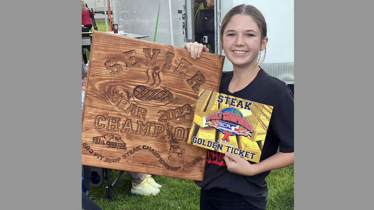 MacKenna York holds up her prize after winning at the Sevier Sear 2023 barbecue competition last June.