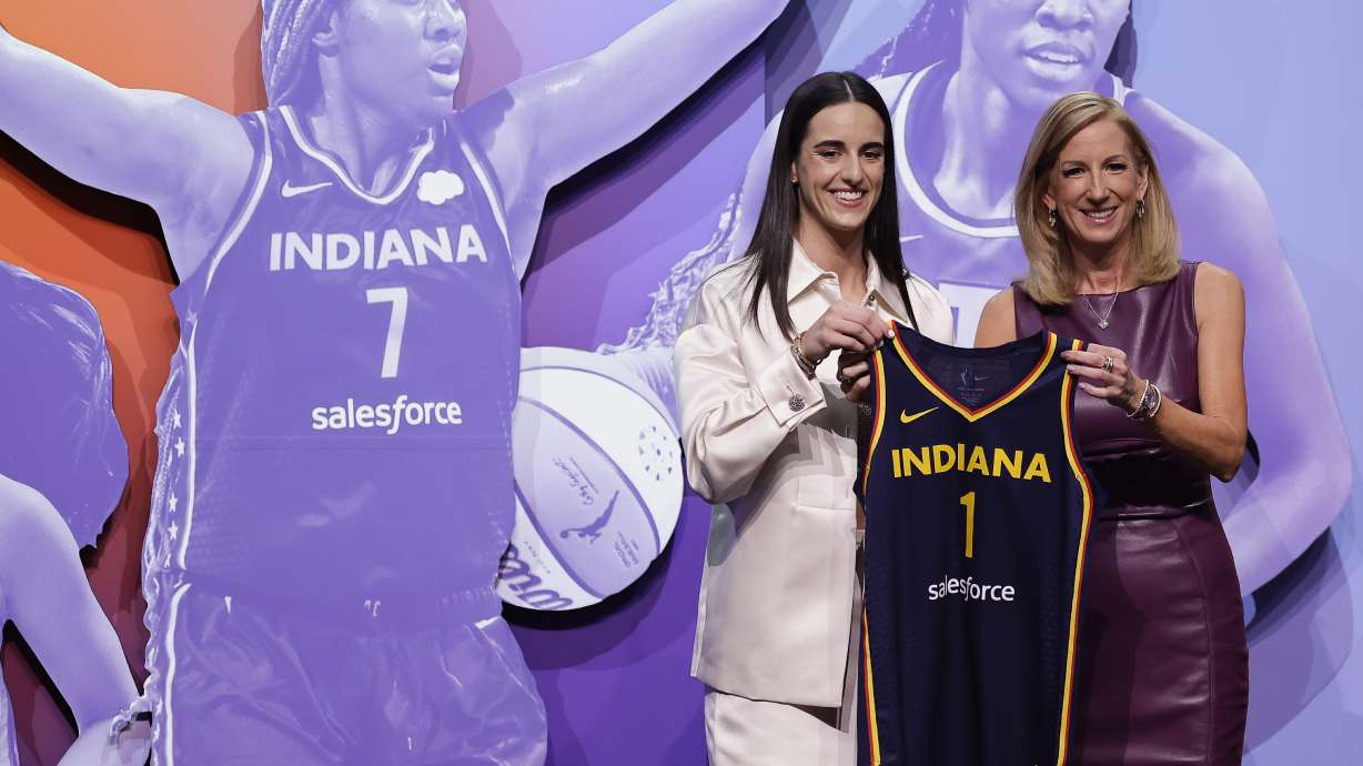 CORRECTS TO CAITLIN CLARK NOT CAITLYN CLARK - Iowa's Caitlin Clark, left, poses for a photo with WNBA commissioner Cathy Engelbert, right, after being selected first overall by the Indiana Fever during the first round of the WNBA basketball draft, Monday, April 15, 2024, in New York.