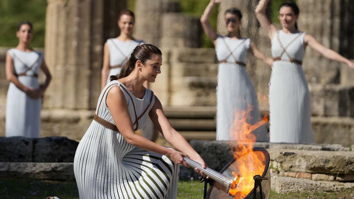 FILE - Greek actress Xanthi Georgiou, playing the role of the High Priestess, lights the torch during the lighting of the Olympic flame at Ancient Olympia site, birthplace of the ancient Olympics in southwestern Greece Oct. 18, 2021. On Tuesday, April 16, 2024 the flame for this summer's Paris Olympics will be lit and be carried through Greece for more than 5,000 kilometers (3,100 miles) before being handed over to French organizers at the Athens site of the first modern Olympics.