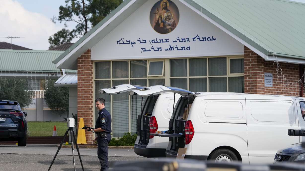 A police officer works at the Christ the Good Shepherd Church in suburban Wakely in western Sydney, Australia, Tuesday. Police say a knife attack that wounded a bishop and a priest during a church service was an act of terrorism.