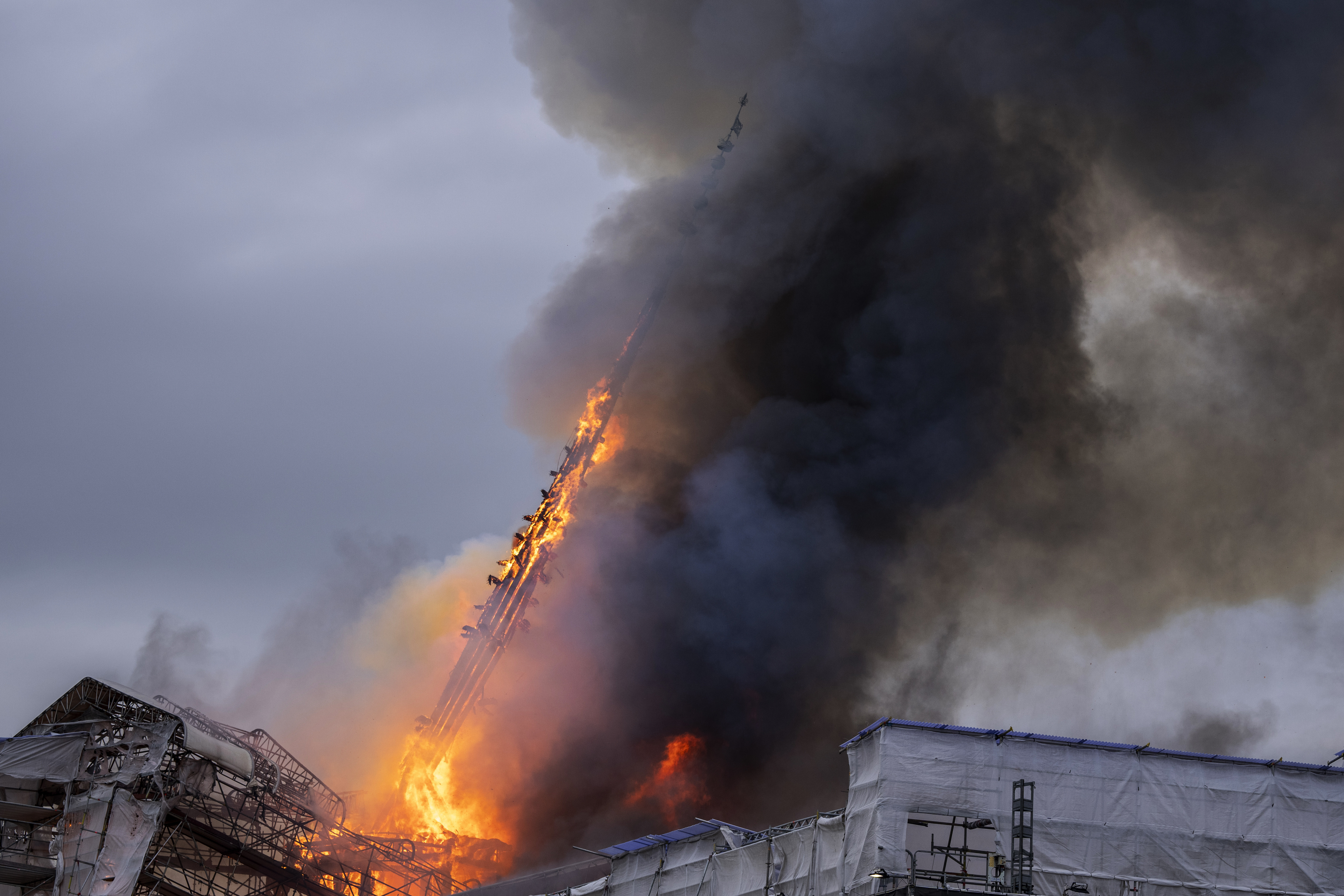 Fire and smoke rise out of the Old Stock Exchange, Boersen, in Copenhagen, Denmark, Tuesday. One of Copenhagen’s oldest buildings is on fire and its iconic spire has collapsed.