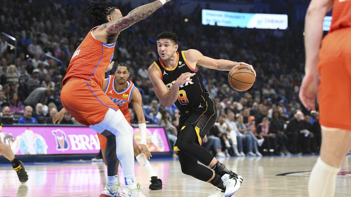 Phoenix Suns guard Grayson Allen, right,drives past Oklahoma City Thunder forward Jaylin Williams, left, during the first half of an NBA basketball game Friday, March 29, 2024, in Oklahoma City.