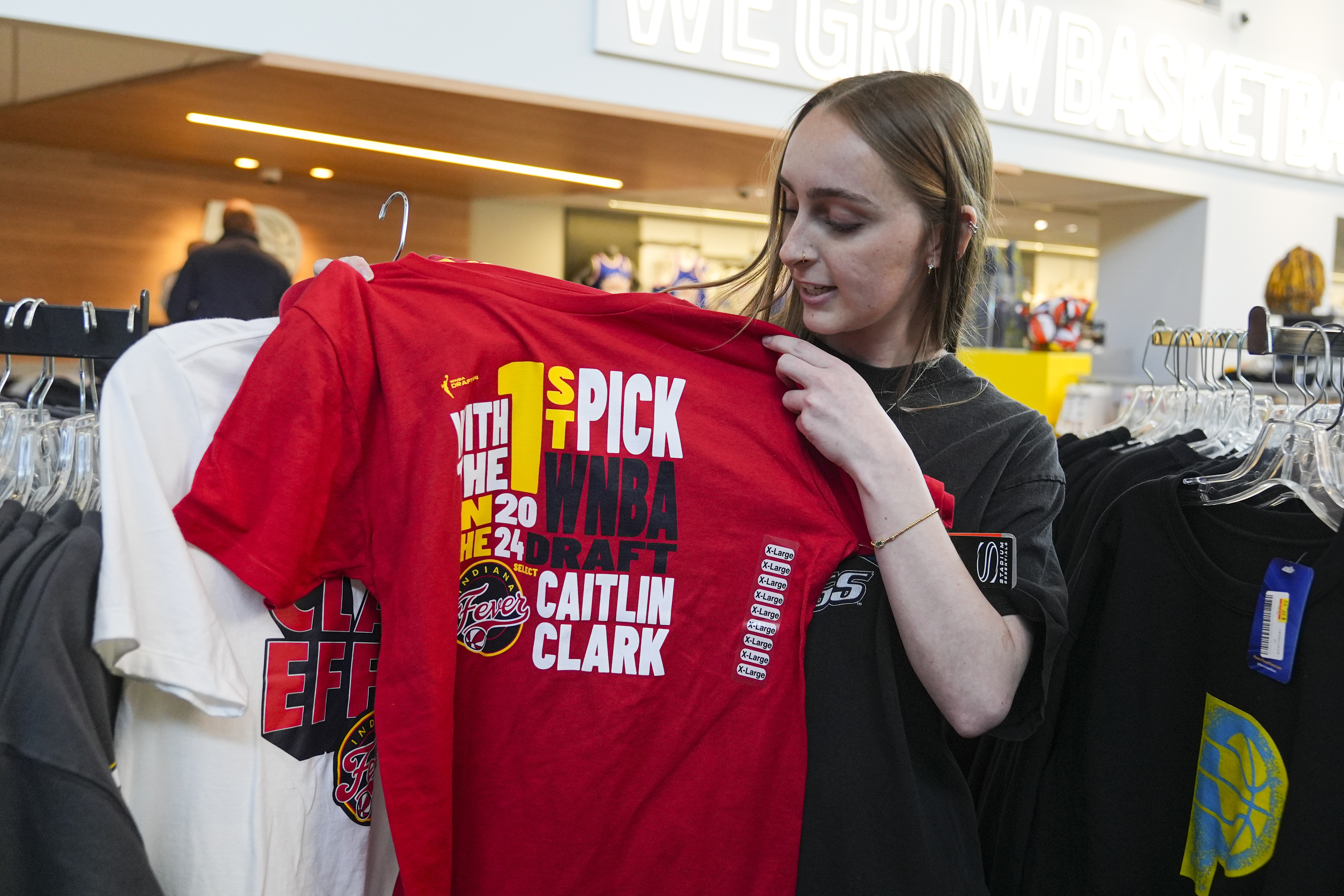 Shelby Tekulve, 20, displays one of the Caitlin Clark shirts she was purchasing in the Indiana Fever team store in Indianapolis, Tuesday, April 16, 2024. The Fever selected Clark as the No. 1 overall pick in the WNBA basketball draft.