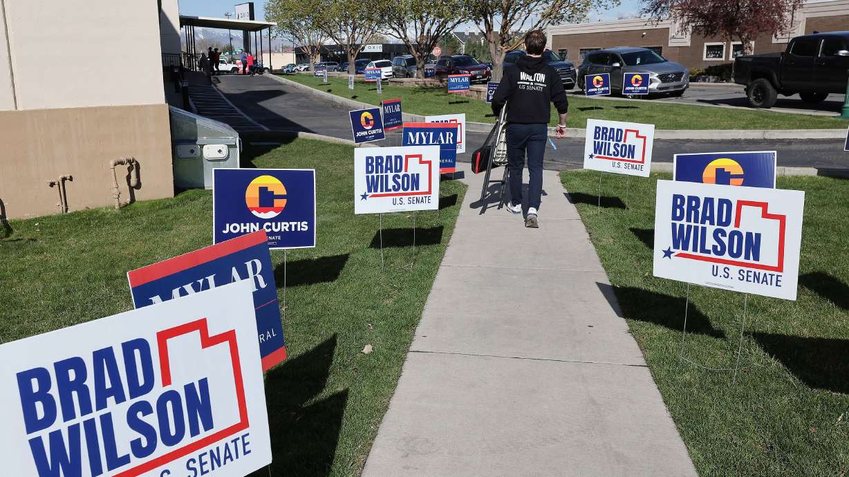 Signs are posted at the U.S. Senate candidate debate at the SCERA Theatre in Orem on Wednesday, April 10. Outside PACs are bombarding delegates with negative ads.