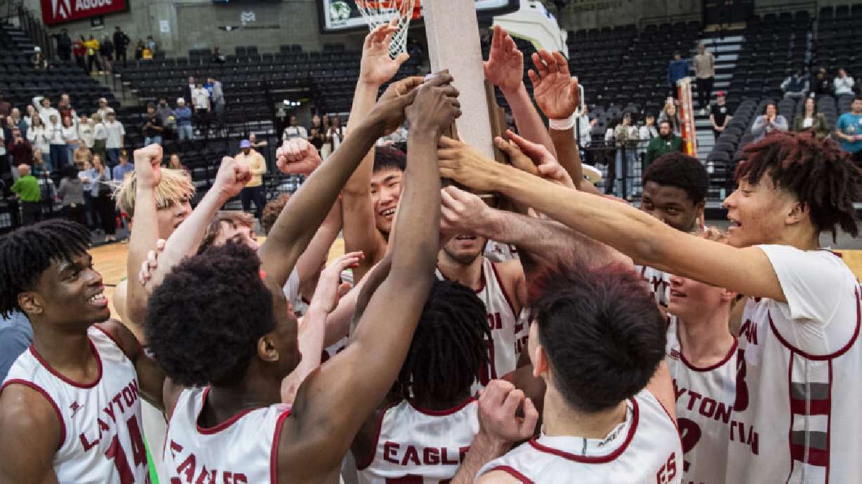 Layton Christian Academy players surround the championship trophy after Layton Christian Academy defeated Cottonwood in the 4A boys basketball state championship game at the UCCU Center in Orem on Feb. 28.
