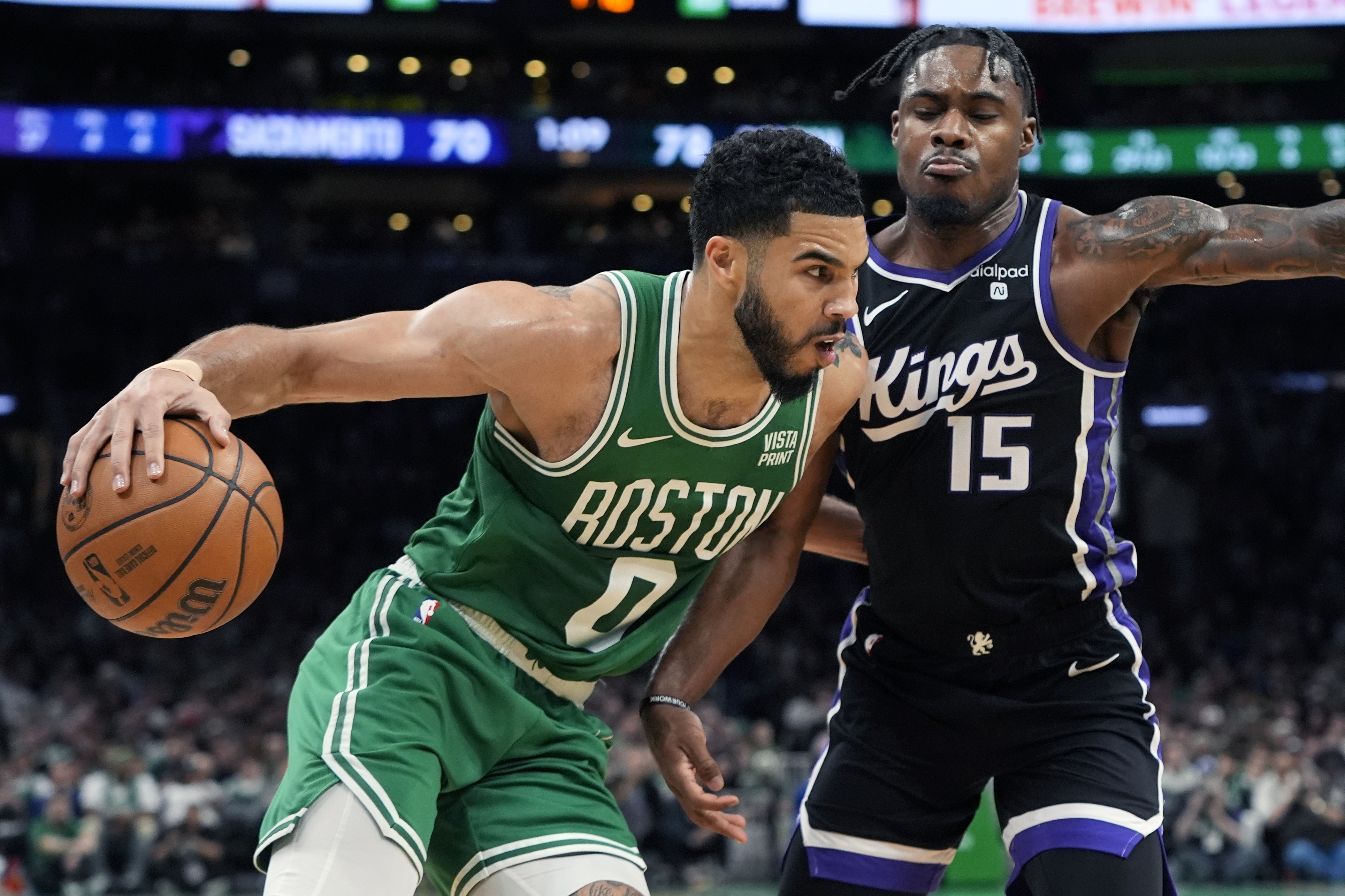 Boston Celtics' Jayson Tatum (0) drives past Sacramento Kings' Davion Mitchell (15) during the second half of an NBA basketball game Friday, April 5, 2024, in Boston.