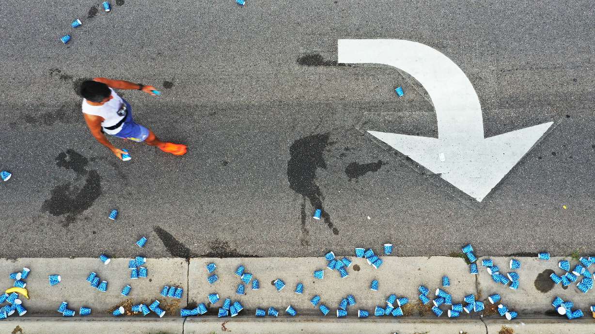 A runner gets water at an aid station during the Deseret News Marathon in Salt Lake City on July 24, 2023. Several road closures are planned for Salt Lake City and surrounding areas for this year's Salt Lake City Marathon on Saturday.