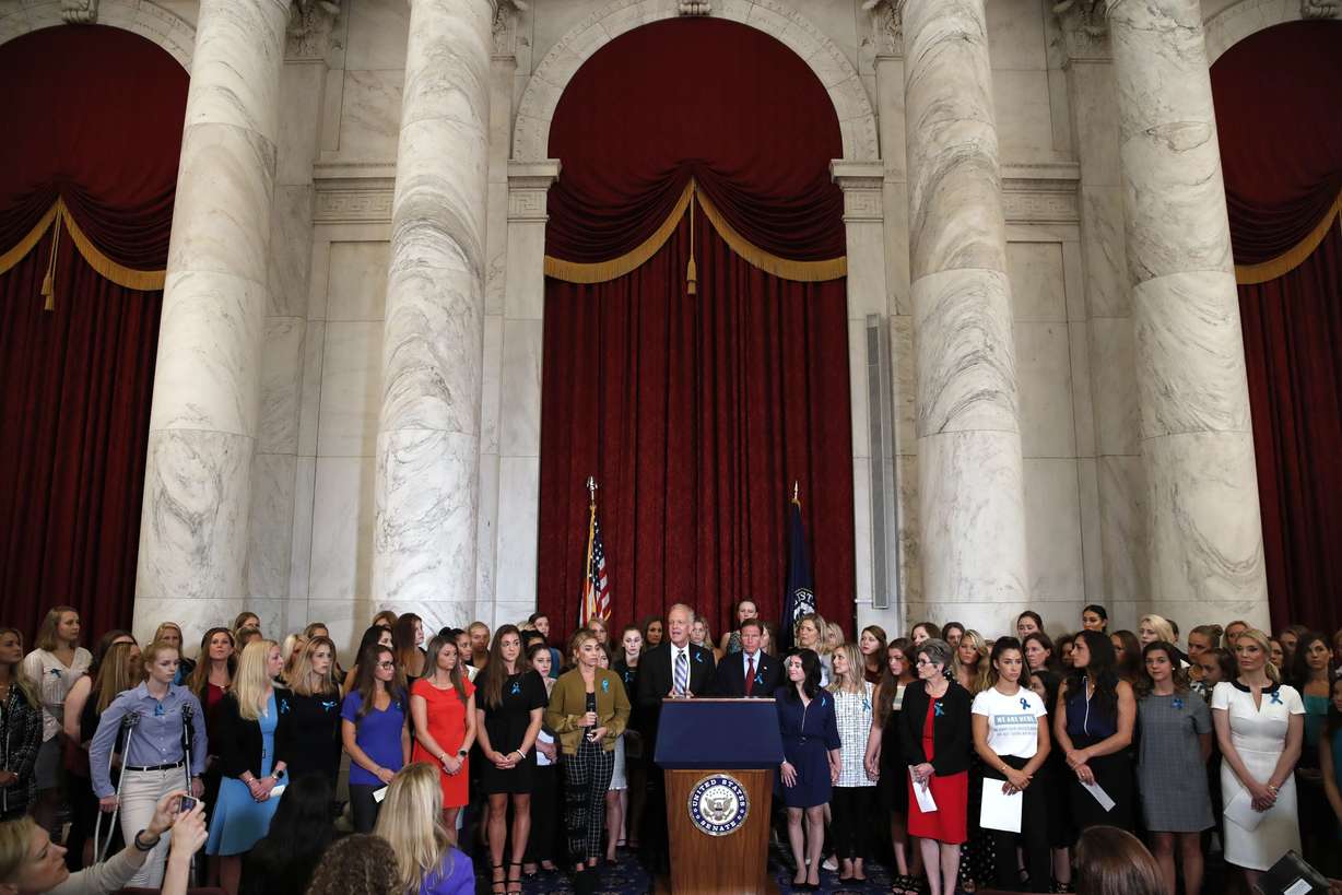 Sen. Jerry Moran, R-Kansas, center left, and Sen. Richard Blumenthal, D-Conn., attend a news conference with dozens of women and girls who were sexually abused by Larry Nassar, a former doctor for Michigan State University athletics and USA Gymnastics, July 24, 2018, on Capitol Hill in Washington. The U.S. Justice Department has agreed to pay approximately $100 million to settle claims with about 100 sexual assault victims of Nassar, a source with direct knowledge of the negotiations told The Associated Press on Wednesday.