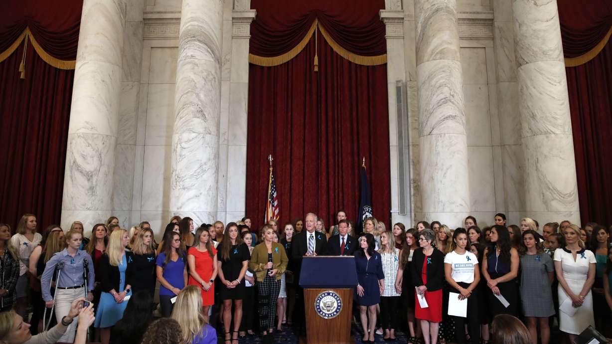 Sen. Jerry Moran, R-Kansas, center left, and Sen. Richard Blumenthal, D-Conn., attend a news conference with dozens of women and girls who were sexually abused by Larry Nassar, a former doctor for Michigan State University athletics and USA Gymnastics, July 24, 2018, on Capitol Hill in Washington. The U.S. Justice Department has agreed to pay approximately $100 million to settle claims with about 100 sexual assault victims of Nassar, a source with direct knowledge of the negotiations told The Associated Press on Wednesday.