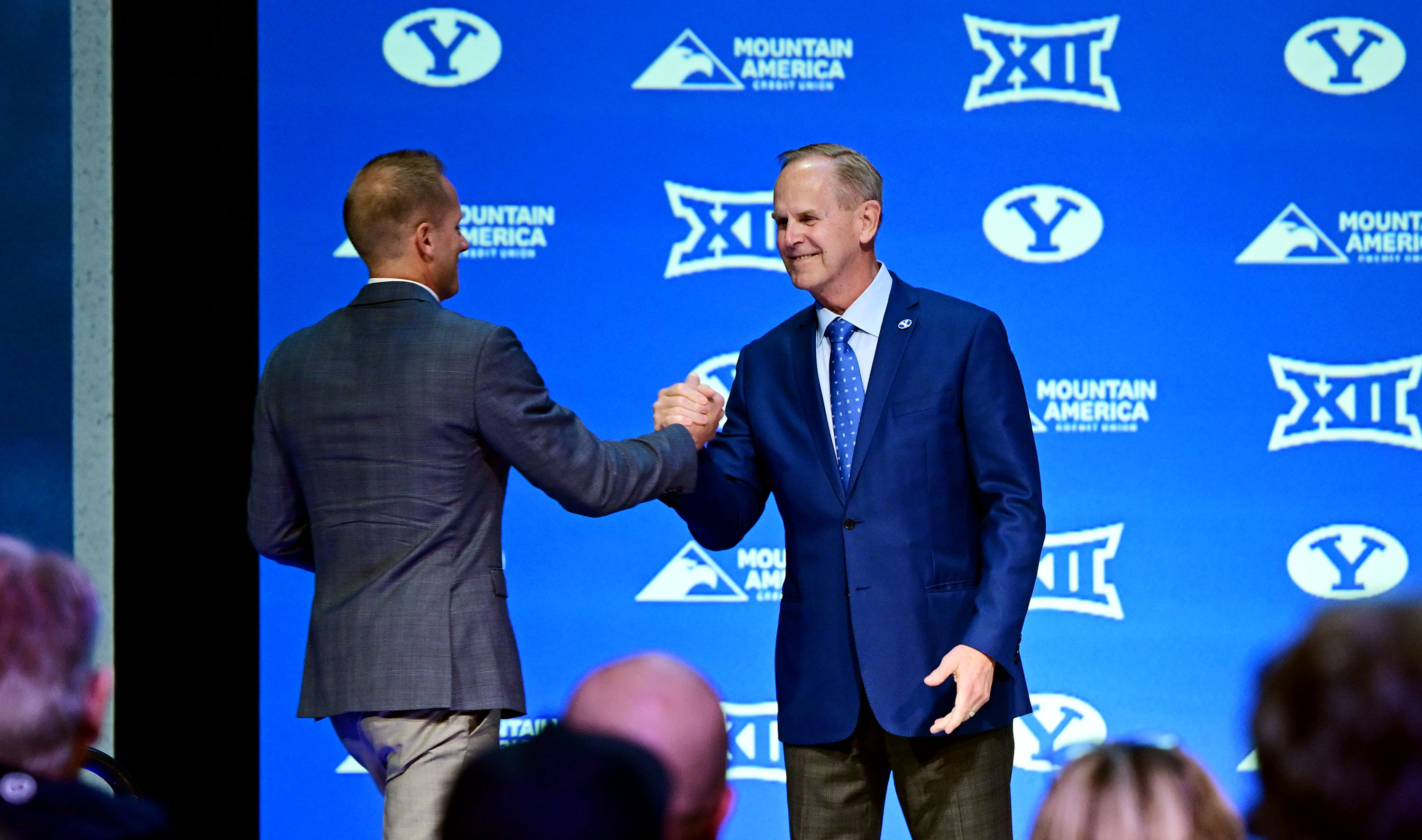 BYU athletic director Tom Holmoe welcomes the new men’s head basketball coach Kevin Young onto the stage at an announcement event in the Marriott Center in Provo on Wednesday, April 17, 2024.